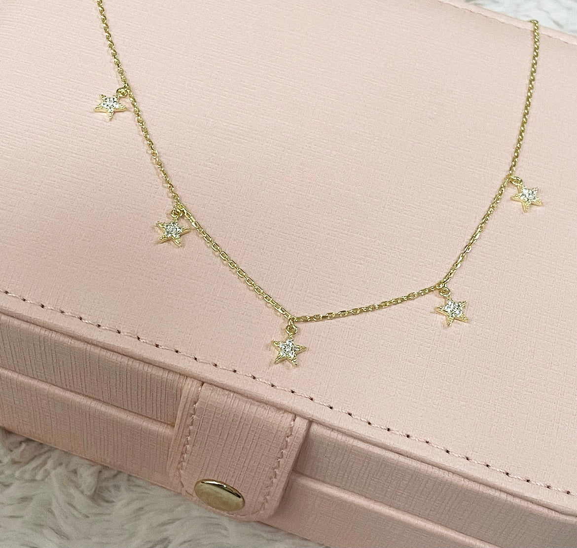 LARA Star Necklace featuring five shiny star charms with cubic zirconias, crafted in 925 Sterling Silver with yellow gold plating.