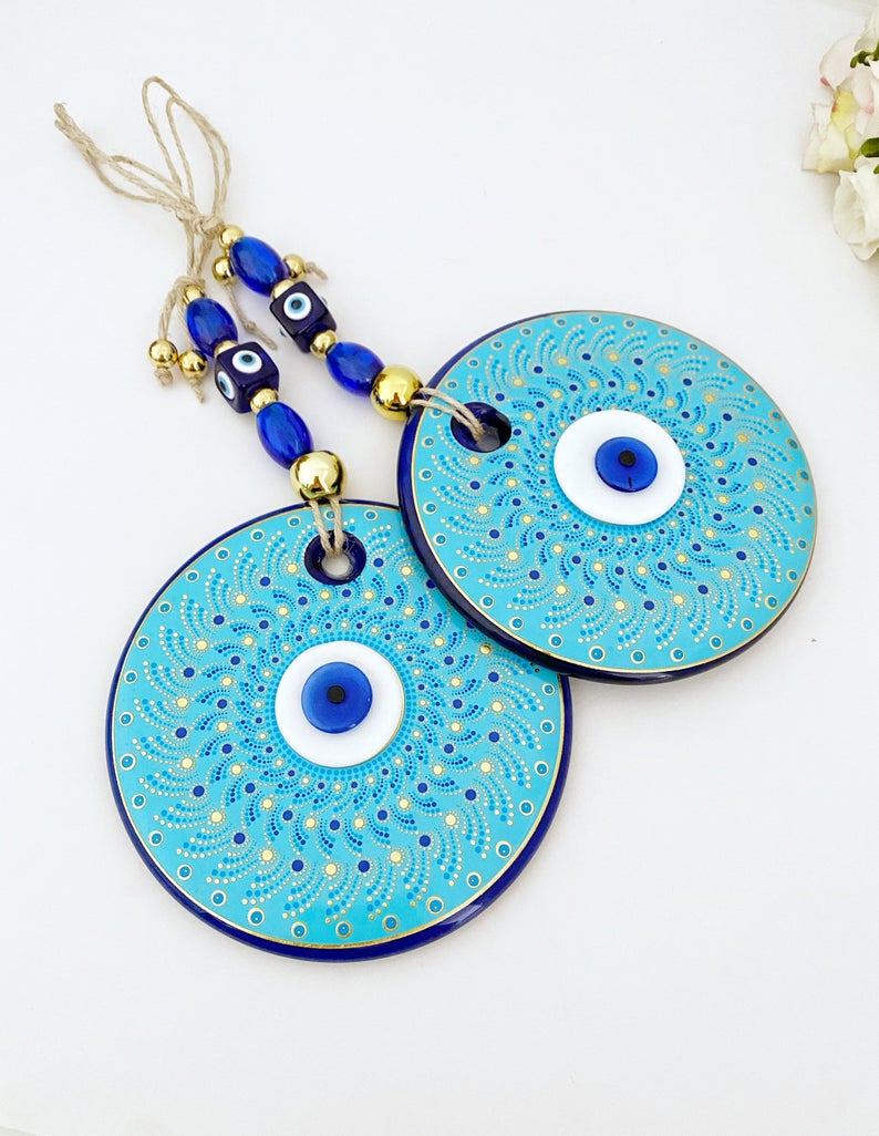 Large blue evil eye wall hanging made of handmade glass, featuring unique fused glass beads, perfect for home decoration.