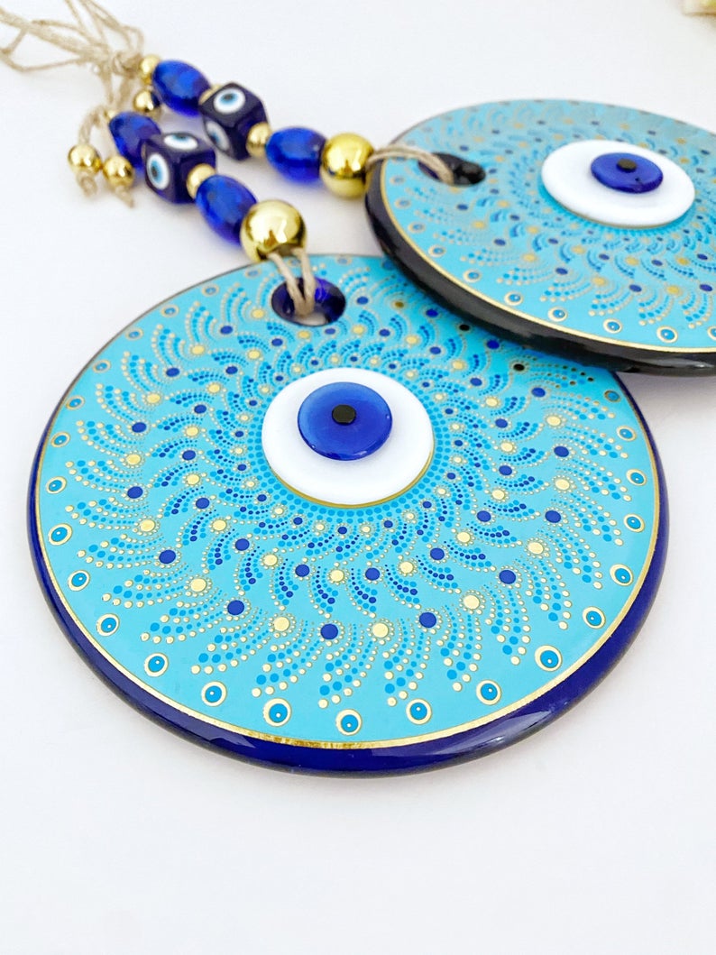 Large blue evil eye wall hanging made of handmade glass, featuring unique fused glass beads, perfect for home decoration.