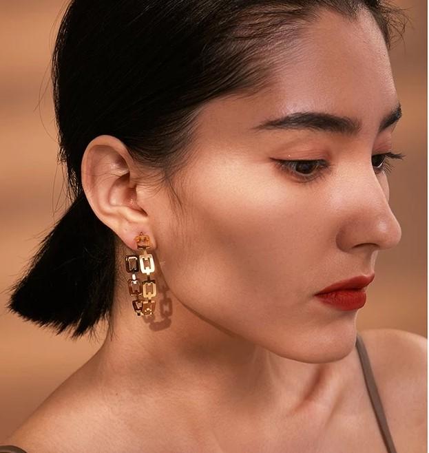 Large gold hoop earrings plated in 18k gold, showcasing a classic design with a shiny finish.