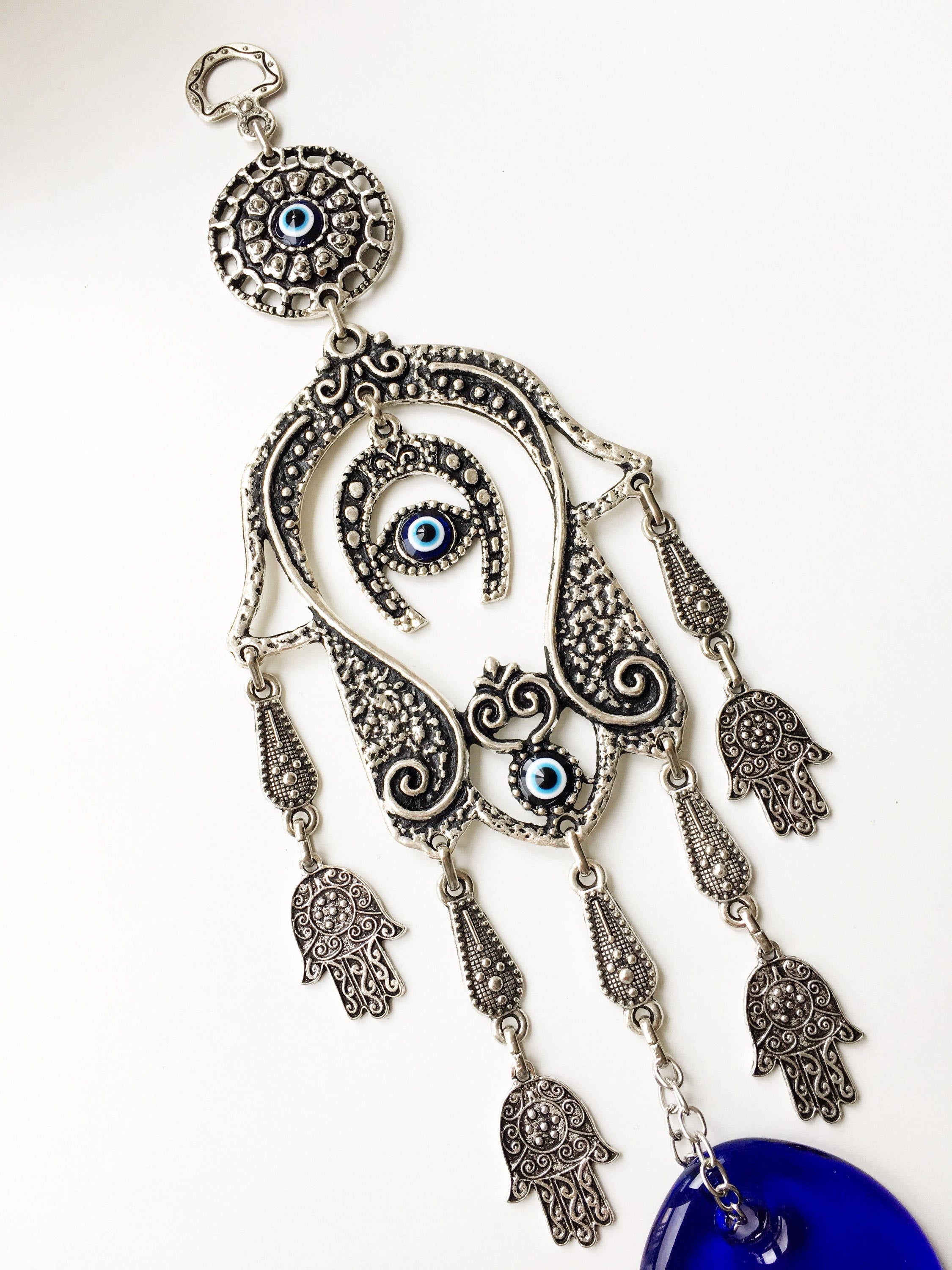 Large Hamsa Evil Eye Wall Hanging featuring a metal Hamsa hand, glass evil eye bead, tiny Hamsa metals, and a horseshoe charm, beautifully crafted for home decor.