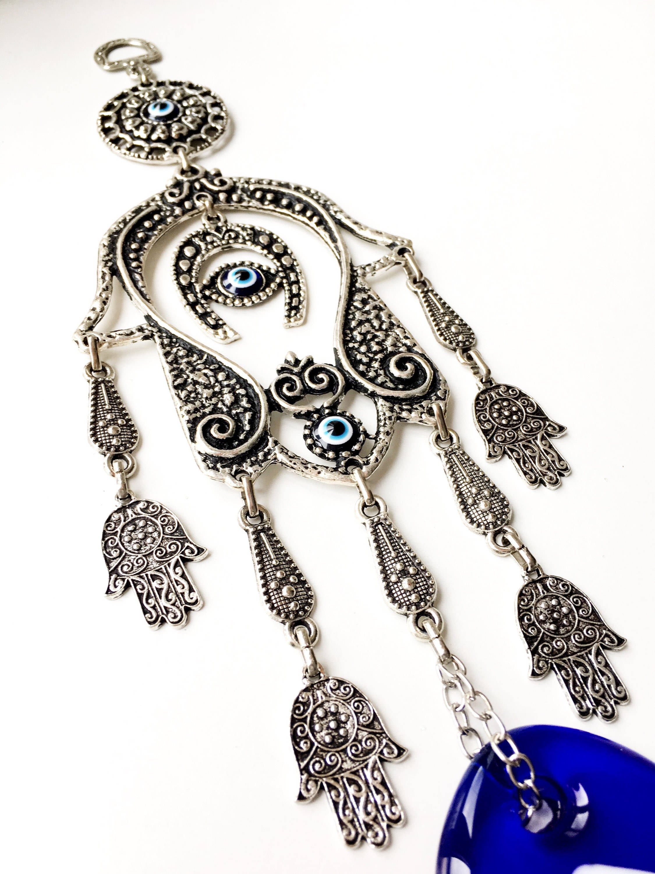 Large Hamsa Evil Eye Wall Hanging featuring a metal Hamsa hand, glass evil eye bead, tiny Hamsa metals, and a horseshoe charm, beautifully crafted for home decor.