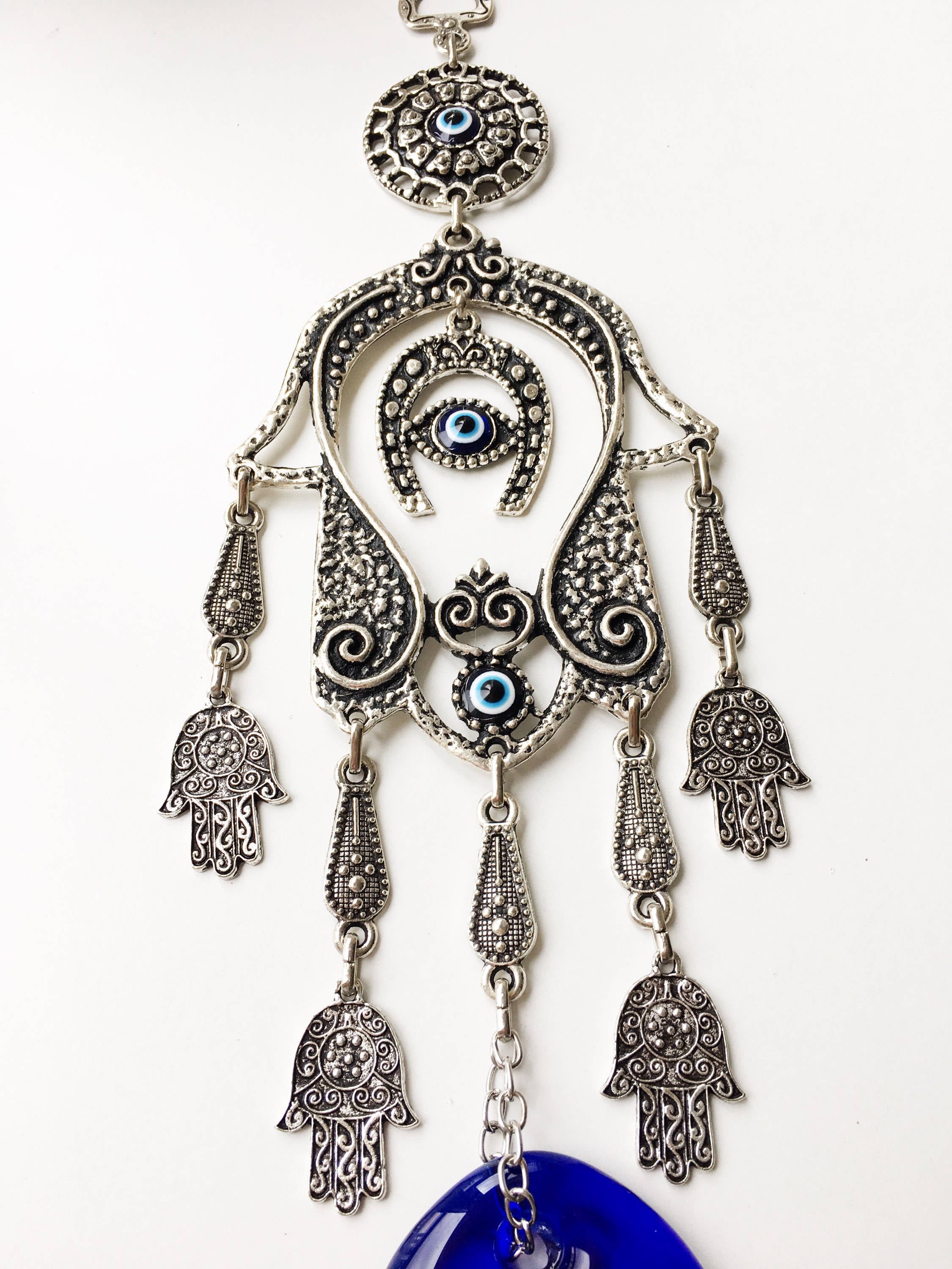 Large Hamsa Evil Eye Wall Hanging featuring a metal Hamsa hand, glass evil eye bead, tiny Hamsa metals, and a horseshoe charm, beautifully crafted for home decor.