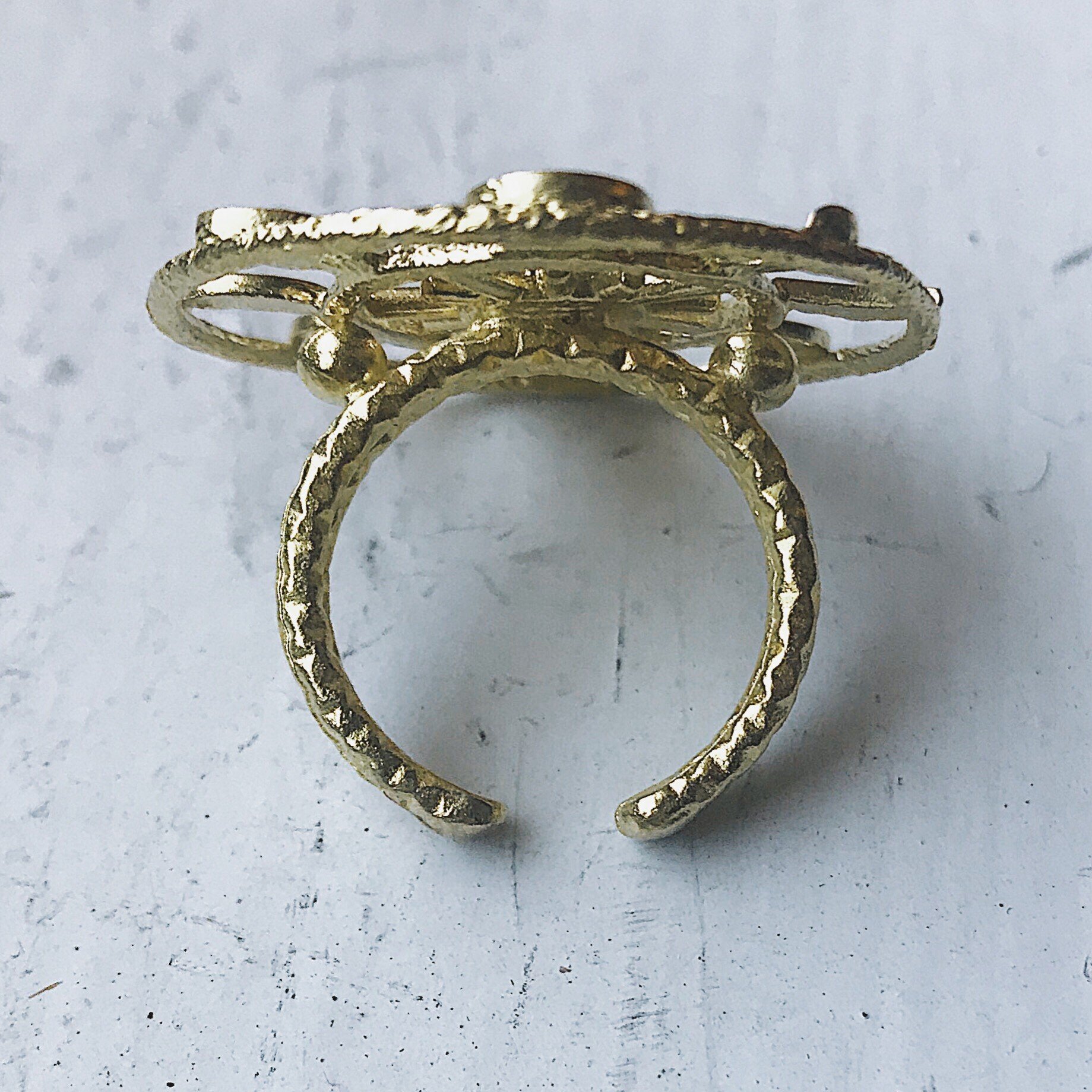 Large Moon Phase Statement Cocktail Ring featuring Earth in glass surrounded by eight moon phases in a textured raw brass gold tone.