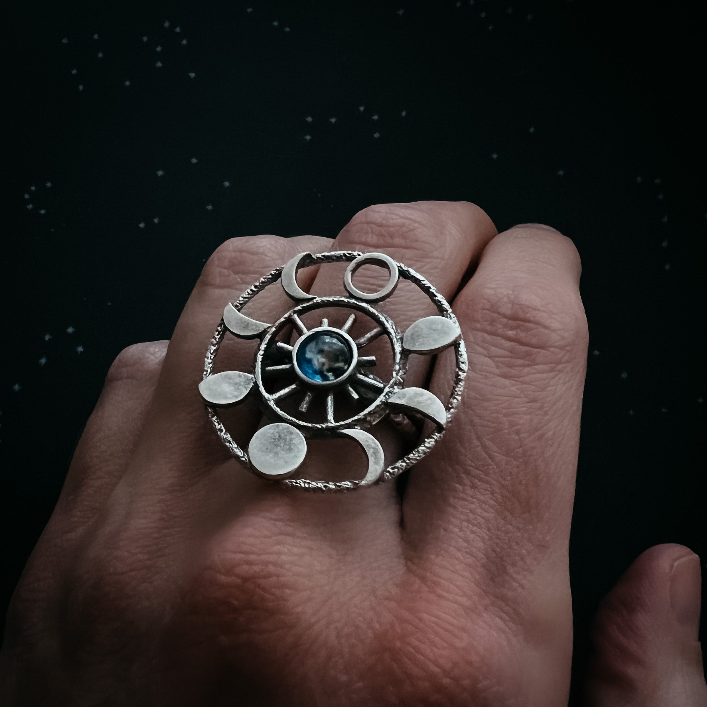 Large Moon Phase Statement Cocktail Ring featuring Earth in glass surrounded by eight moon phases in a textured raw brass gold tone.