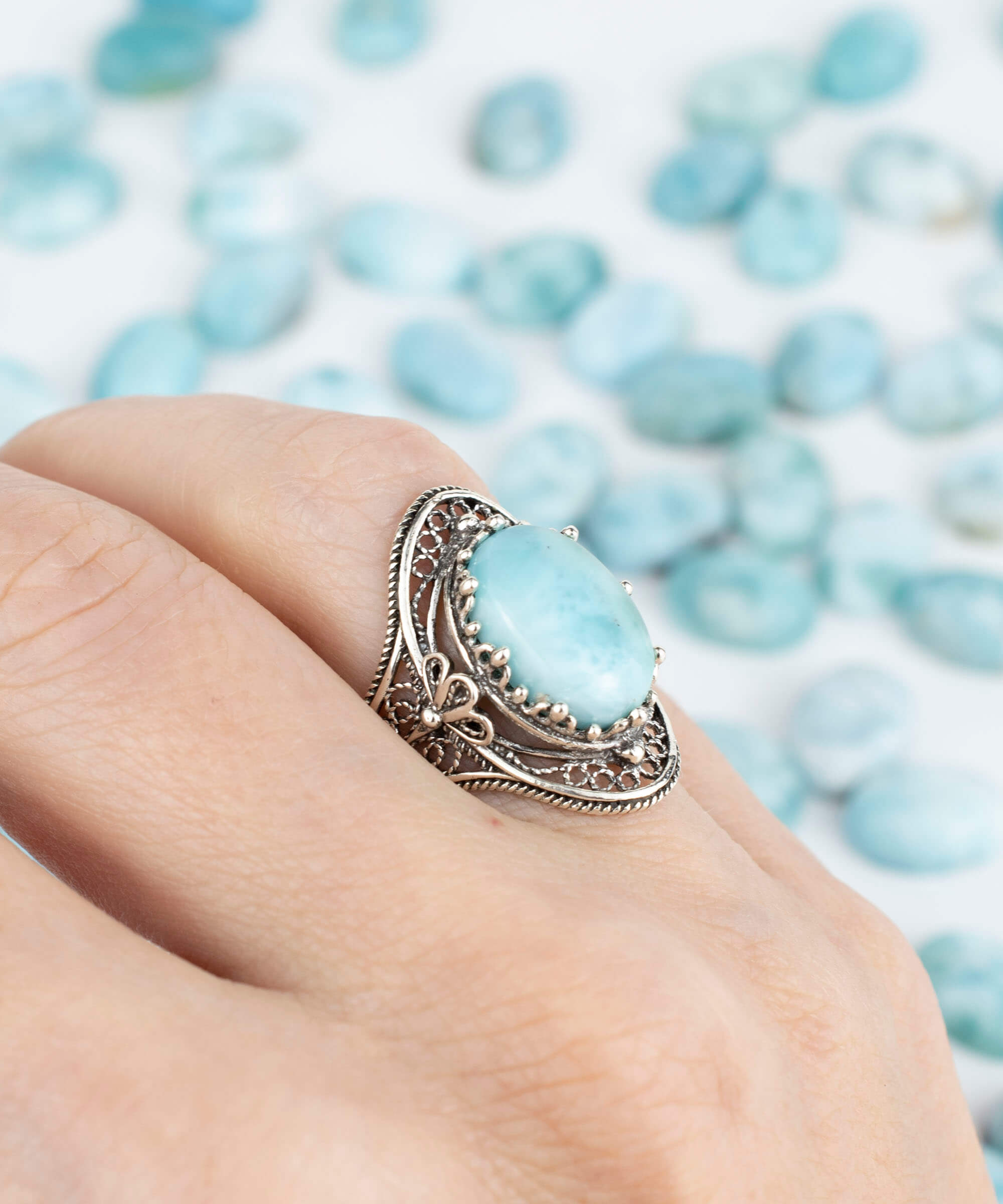 A stunning handmade silver statement ring featuring a polished larimar gemstone in an intricate filigree design, perfect for any occasion.