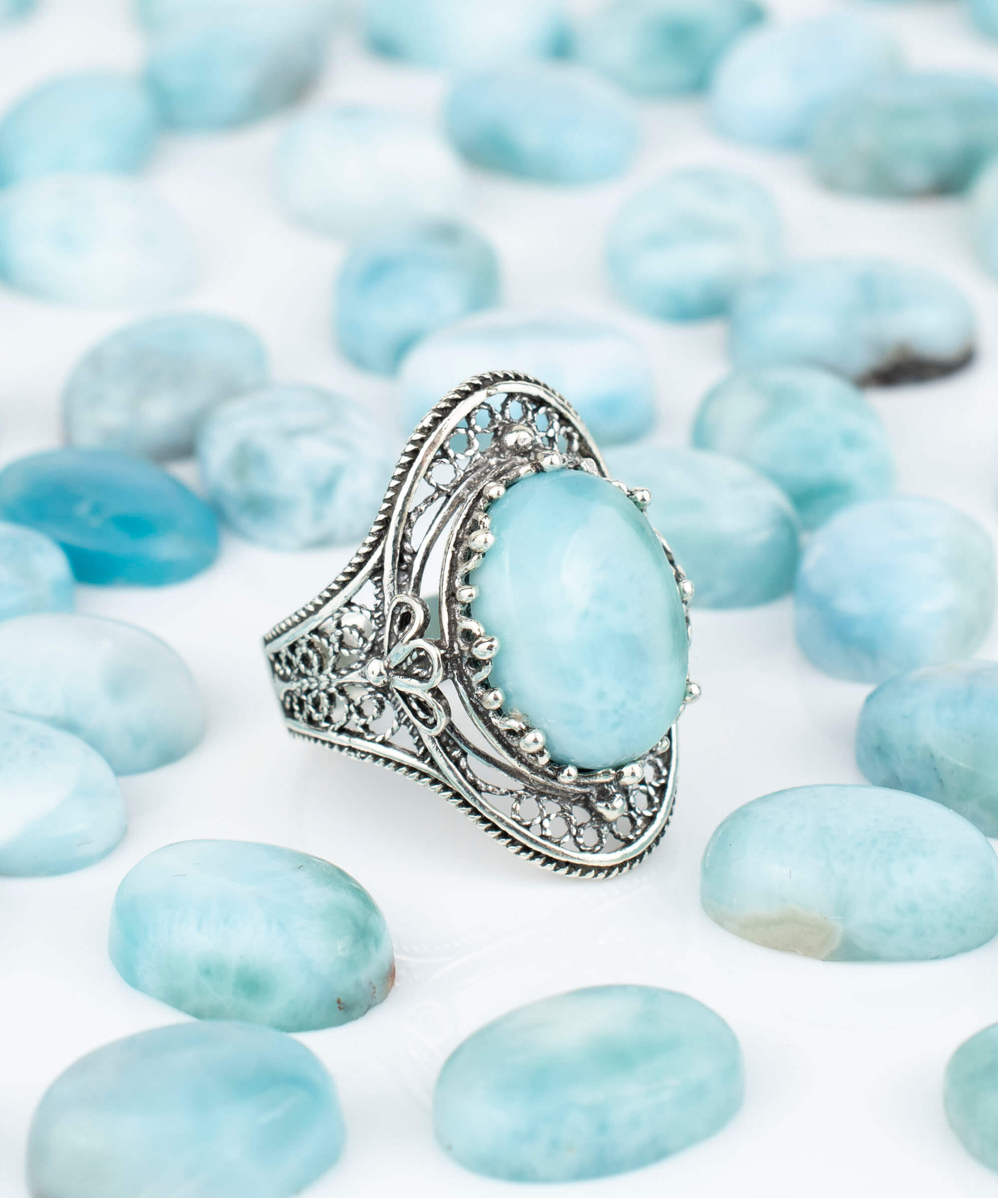 A stunning handmade silver statement ring featuring a polished larimar gemstone in an intricate filigree design, perfect for any occasion.