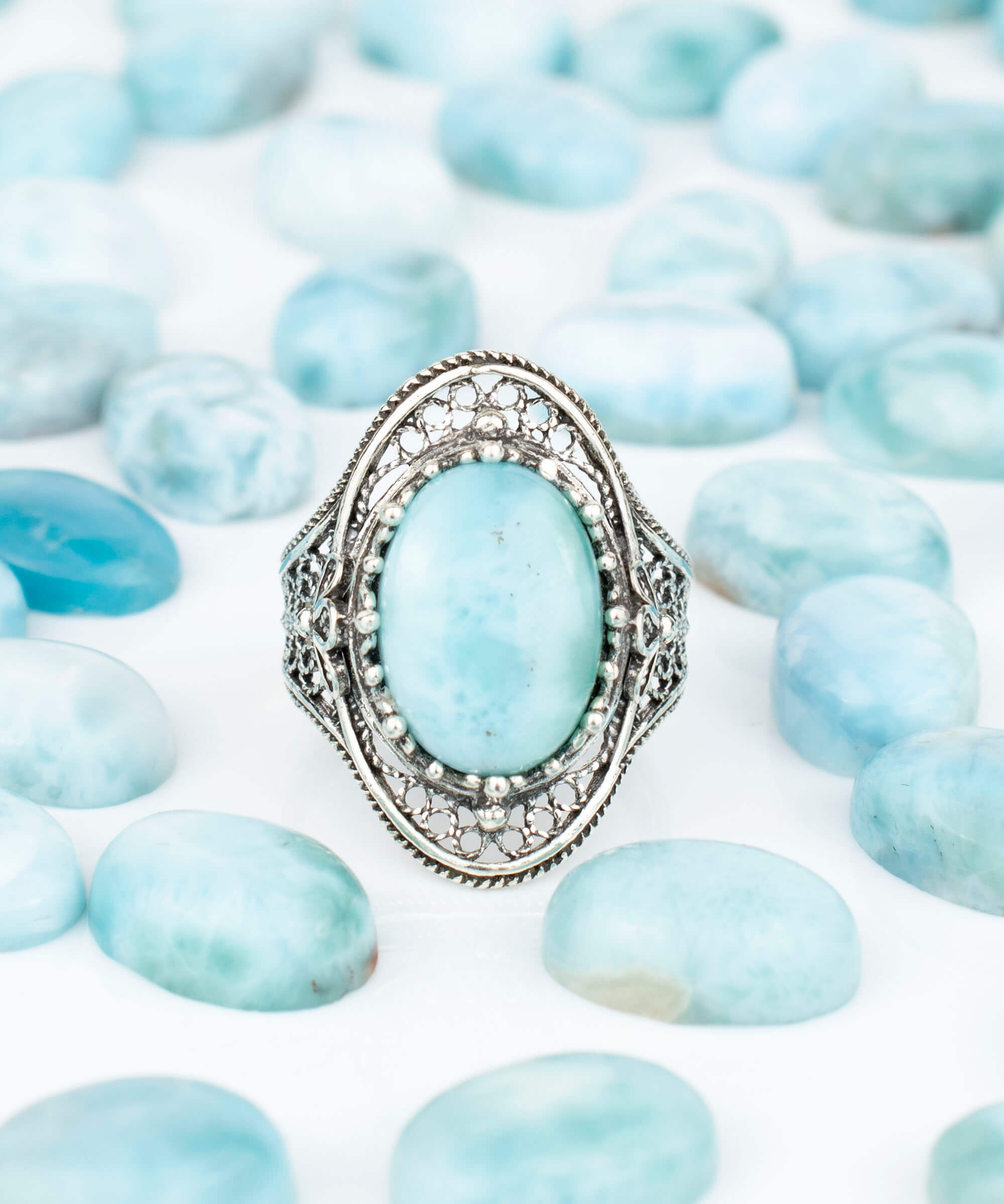 A stunning handmade silver statement ring featuring a polished larimar gemstone in an intricate filigree design, perfect for any occasion.