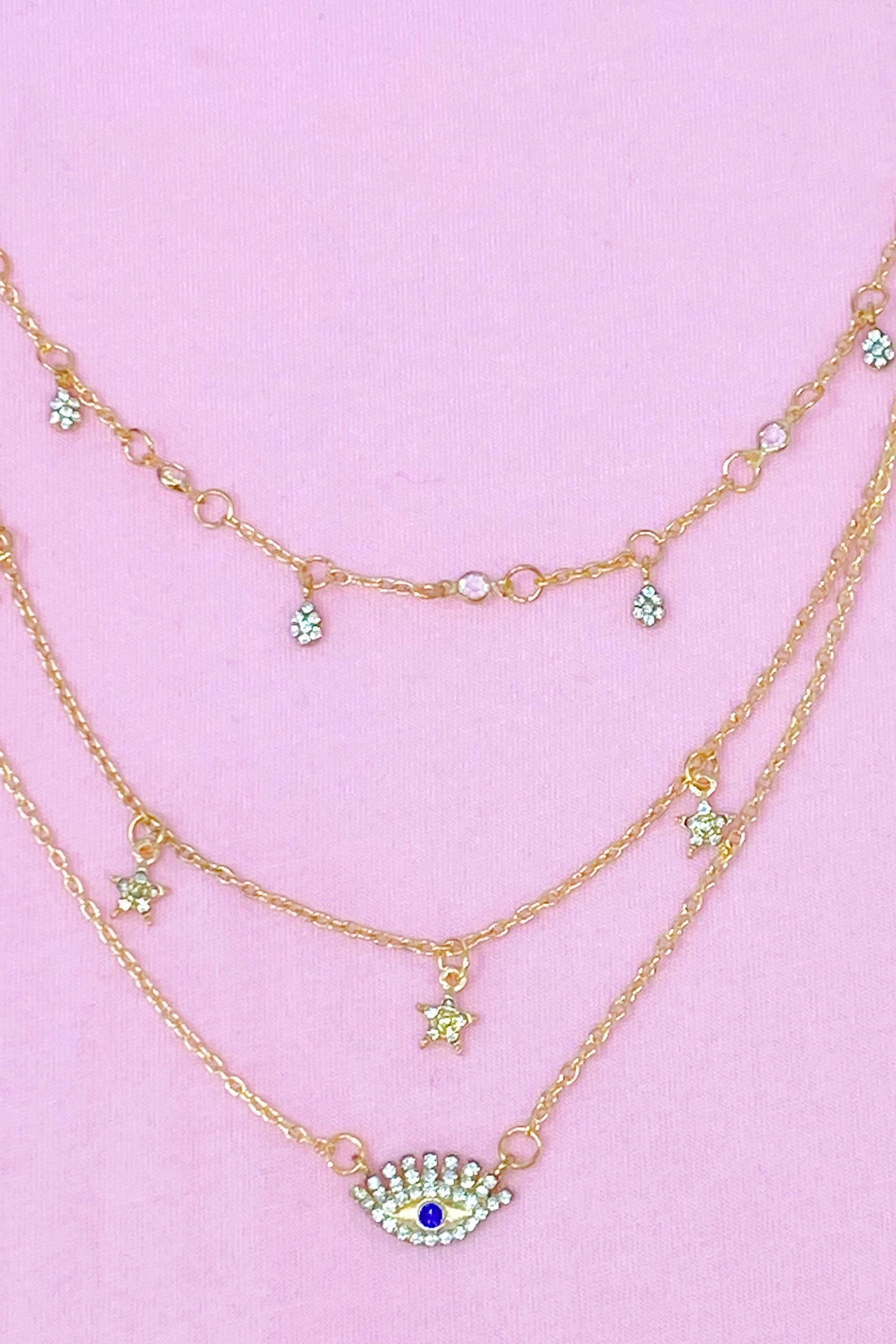 Layered Admiration Necklace featuring triple layers with stars and eye elements in gold-tone plated alloy.