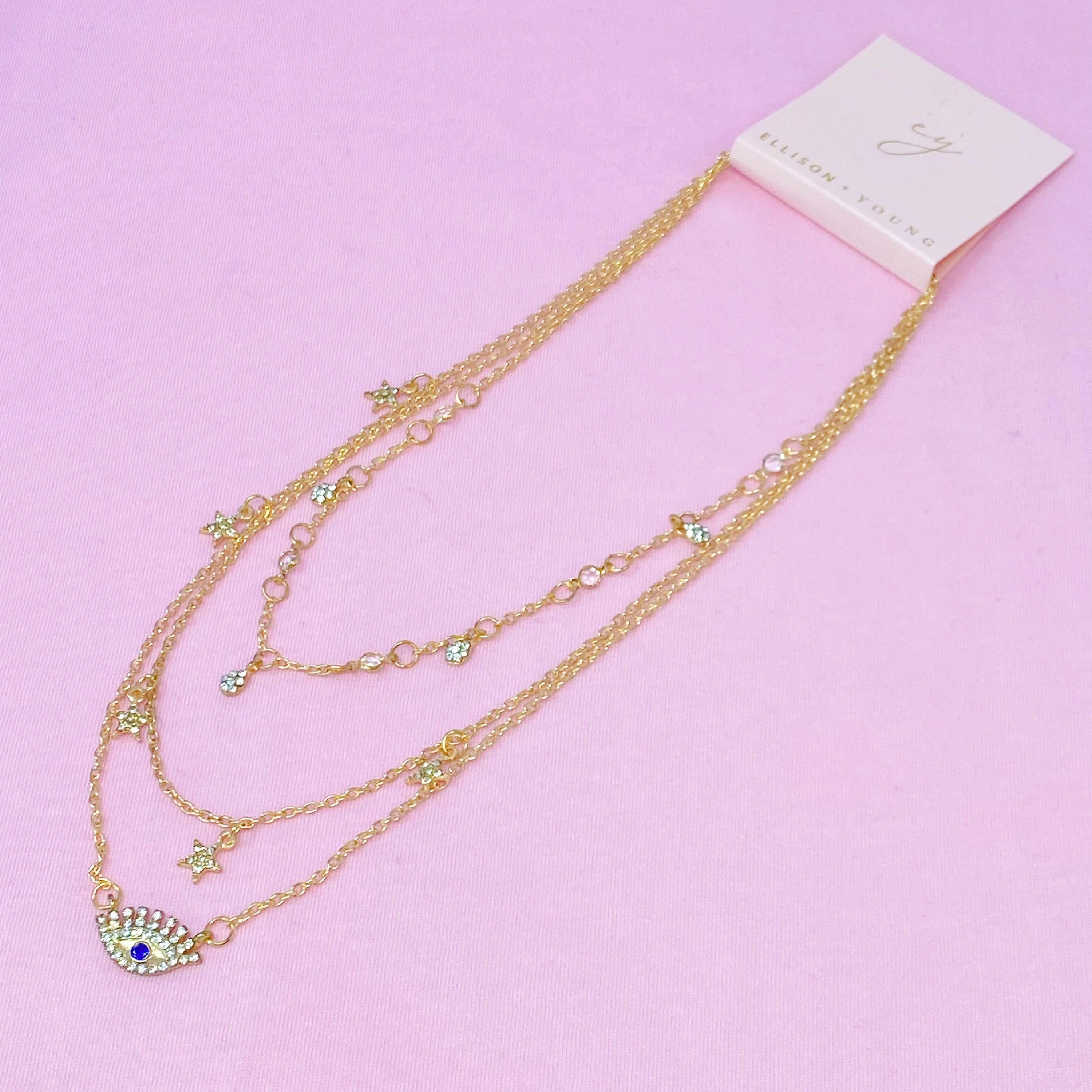 Layered Admiration Necklace featuring triple layers with stars and eye elements in gold-tone plated alloy.