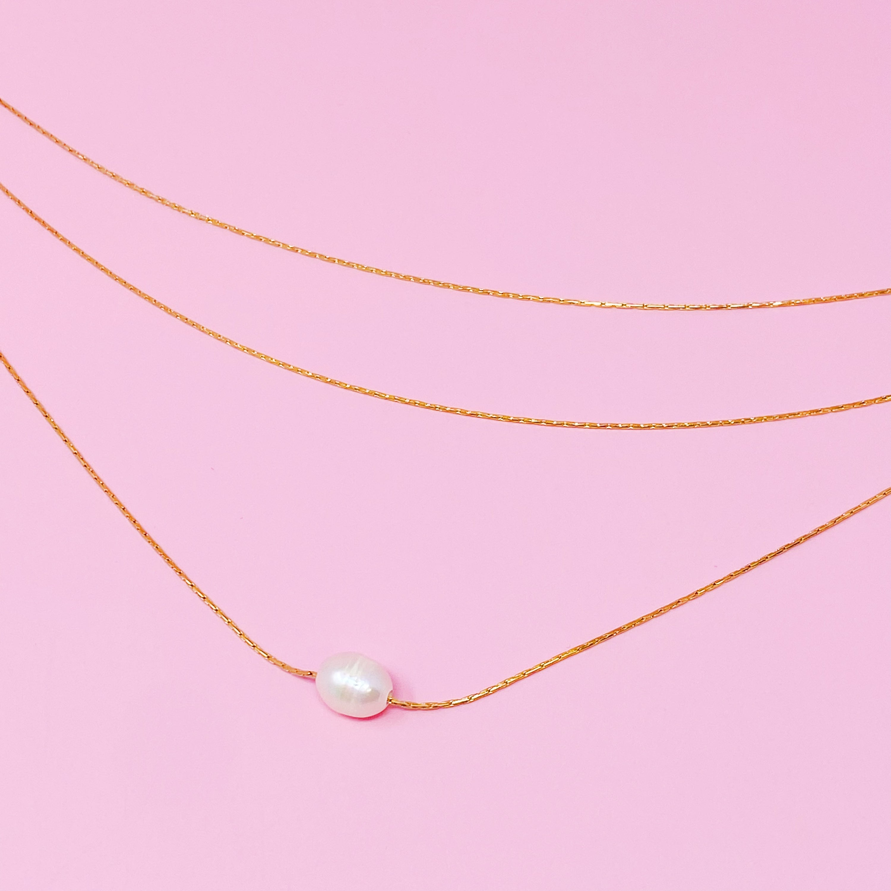 Layered Freshwater Pearl Pendant Necklace featuring a single pearl on gold plated stainless steel chains, showcasing elegance and sophistication.