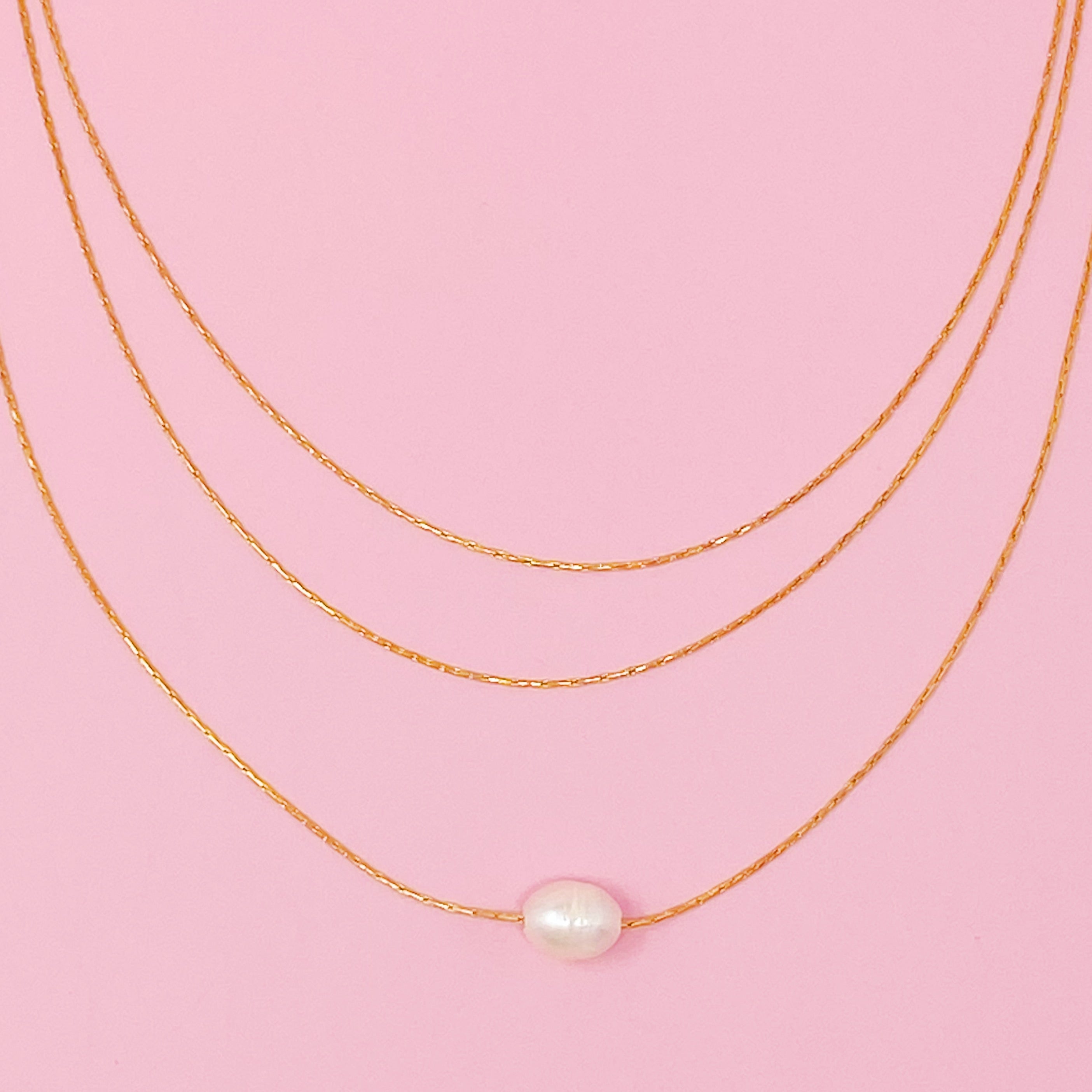 Layered Freshwater Pearl Pendant Necklace featuring a single pearl on gold plated stainless steel chains, showcasing elegance and sophistication.