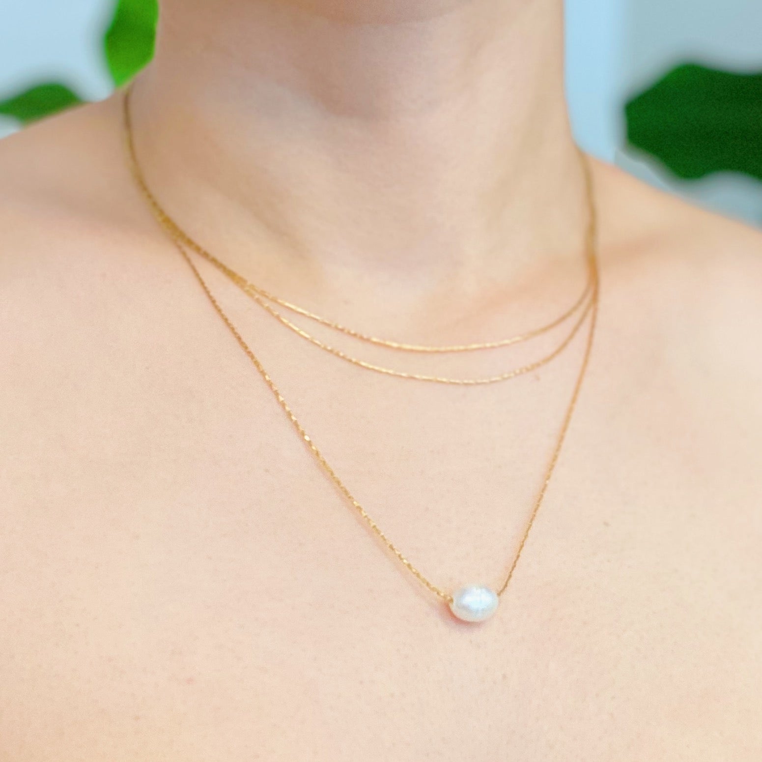 Layered Freshwater Pearl Pendant Necklace featuring a single pearl on gold plated stainless steel chains, showcasing elegance and sophistication.