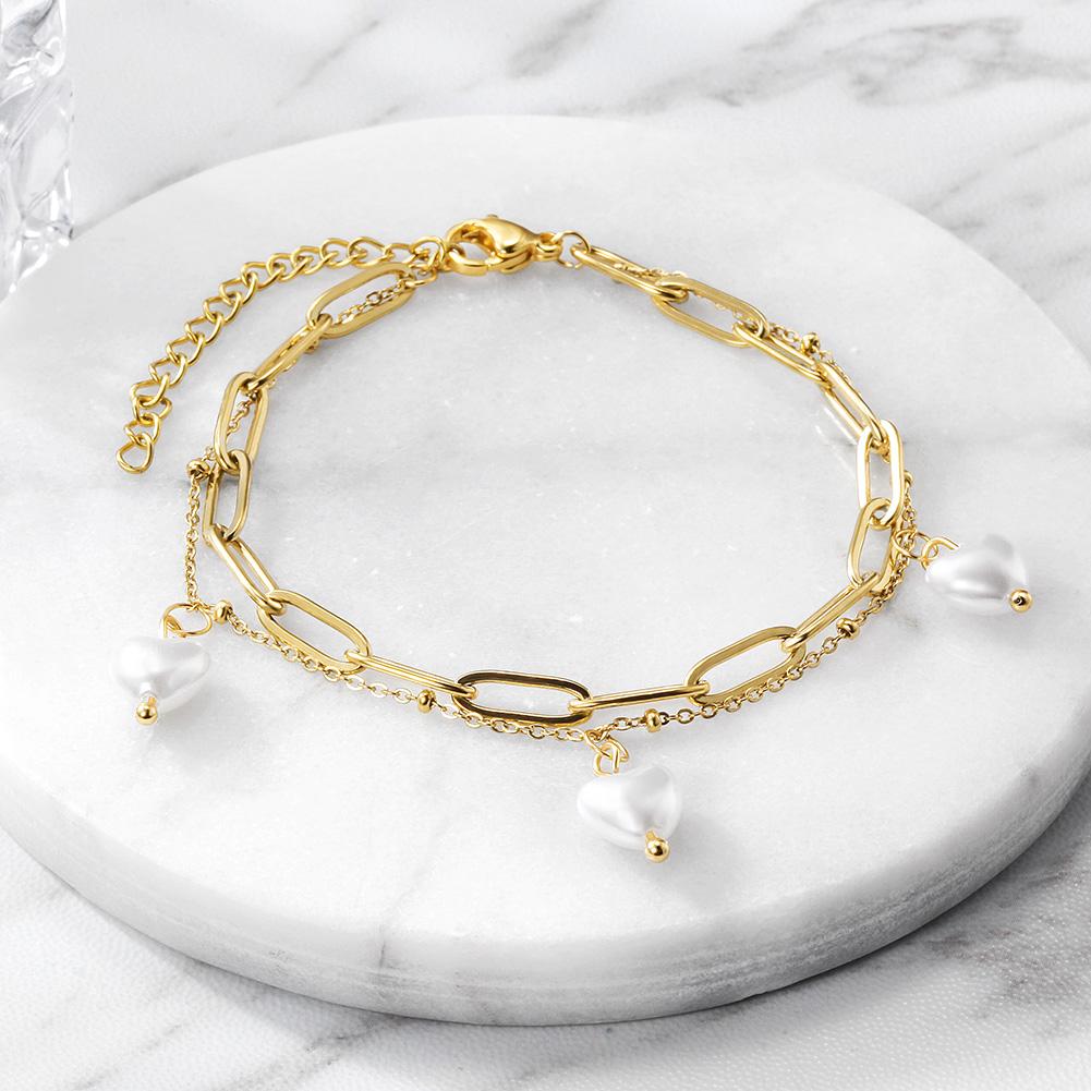 Layered heart-shaped pearl bracelet made of surgical stainless steel with 14K gold PVD plating, showcasing elegance and durability.