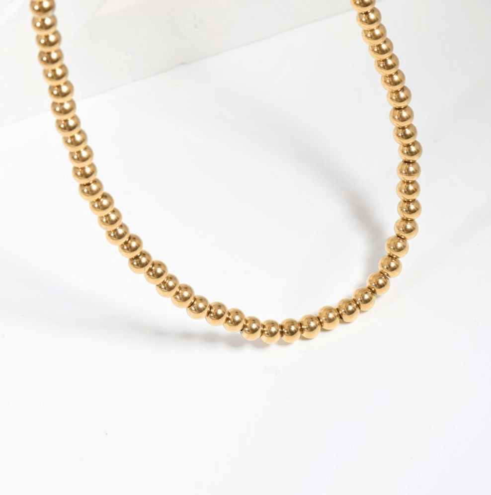 Leonidas Ball Beaded Necklace featuring gold beaded design and stainless steel material, showcasing elegance and durability.