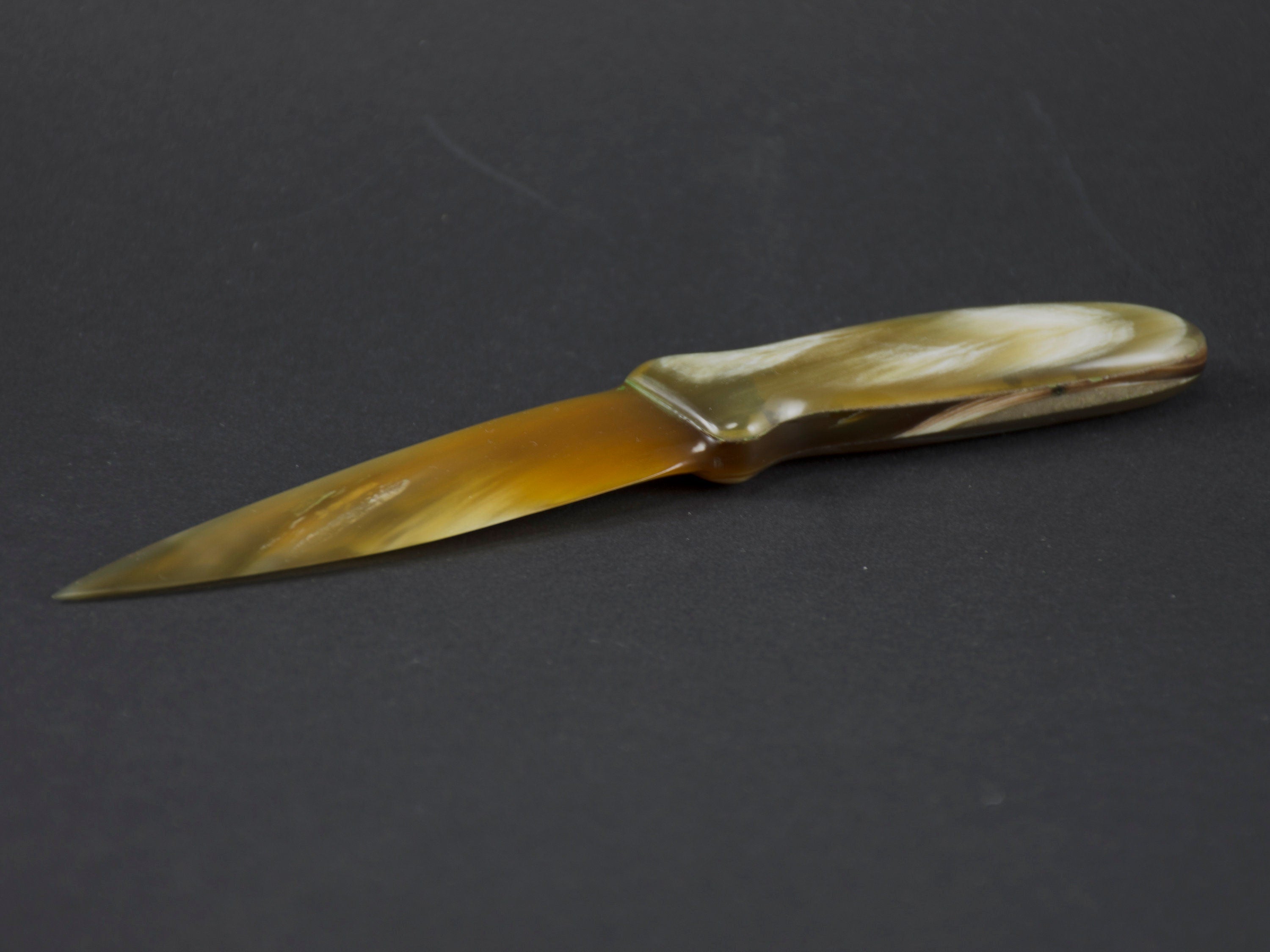 Handmade letter opener crafted from polished cow horn, featuring a sharp blade and elegant design.