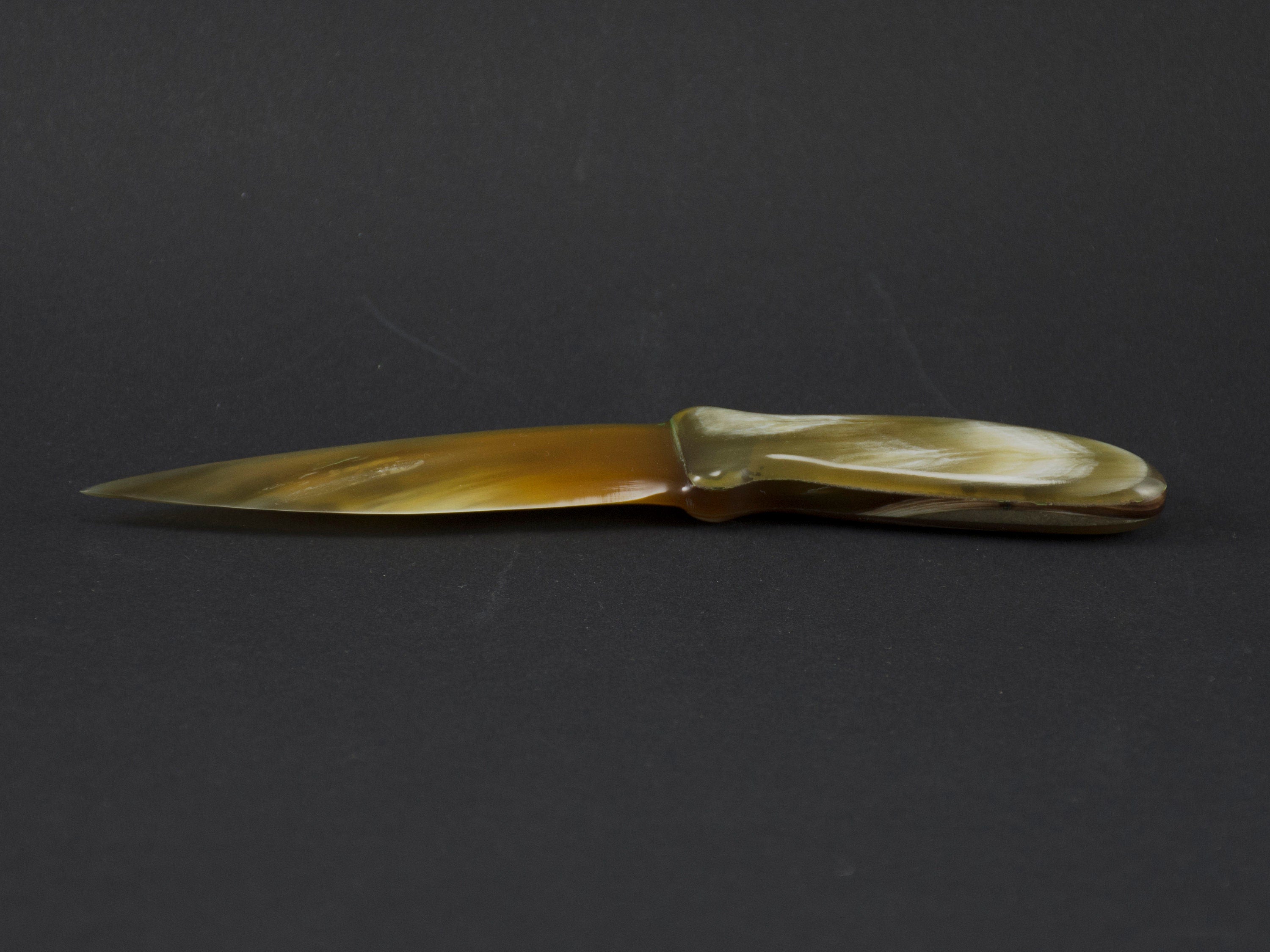 Handmade letter opener crafted from polished cow horn, featuring a sharp blade and elegant design.