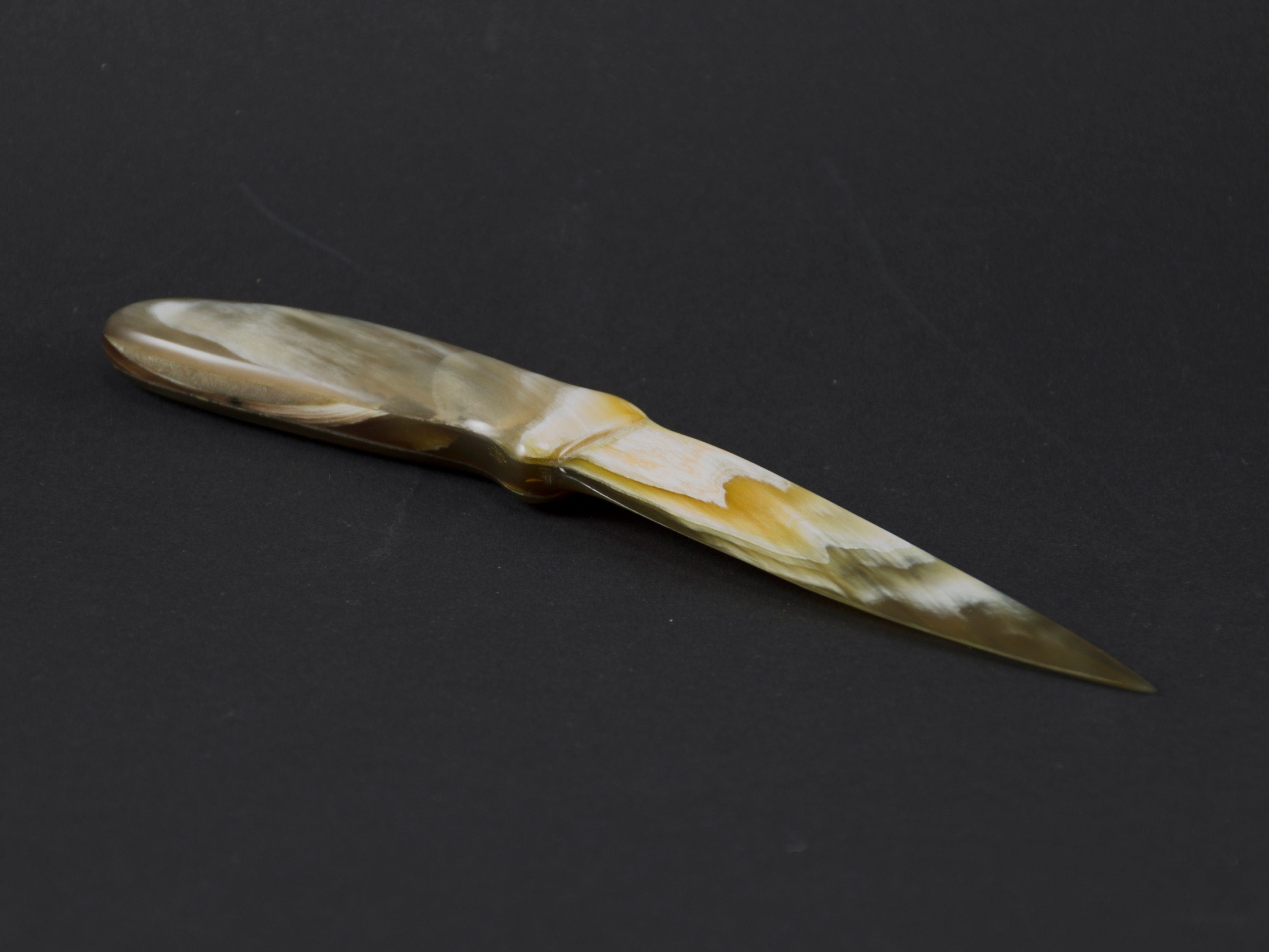 Handmade letter opener crafted from polished cow horn, featuring a sharp blade and elegant design.