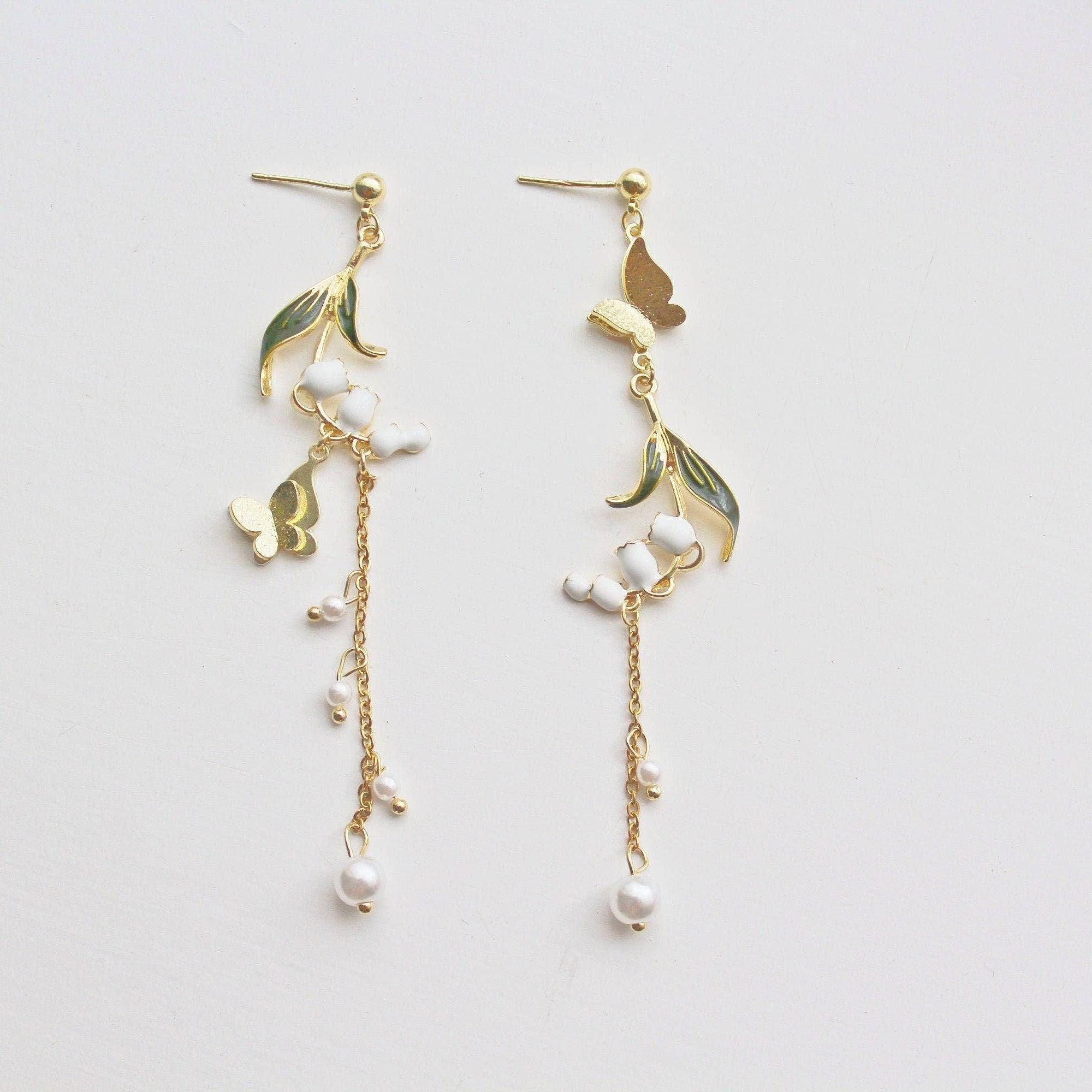 Elegant Lily of the Valley asymmetric drop earrings in gold plated bronze and sterling silver, symbolizing purity and happiness.