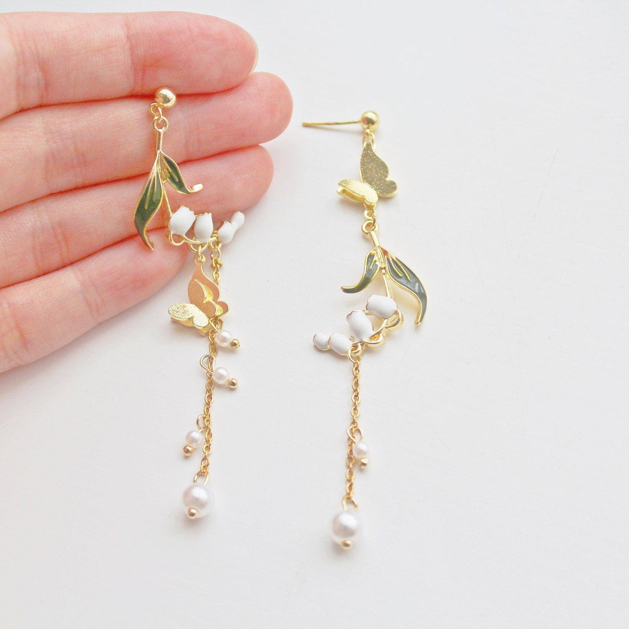 Elegant Lily of the Valley asymmetric drop earrings in gold plated bronze and sterling silver, symbolizing purity and happiness.