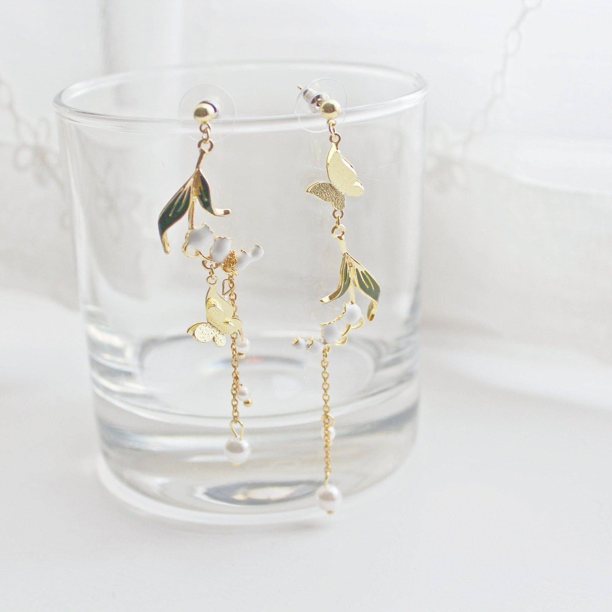 Elegant Lily of the Valley asymmetric drop earrings in gold plated bronze and sterling silver, symbolizing purity and happiness.