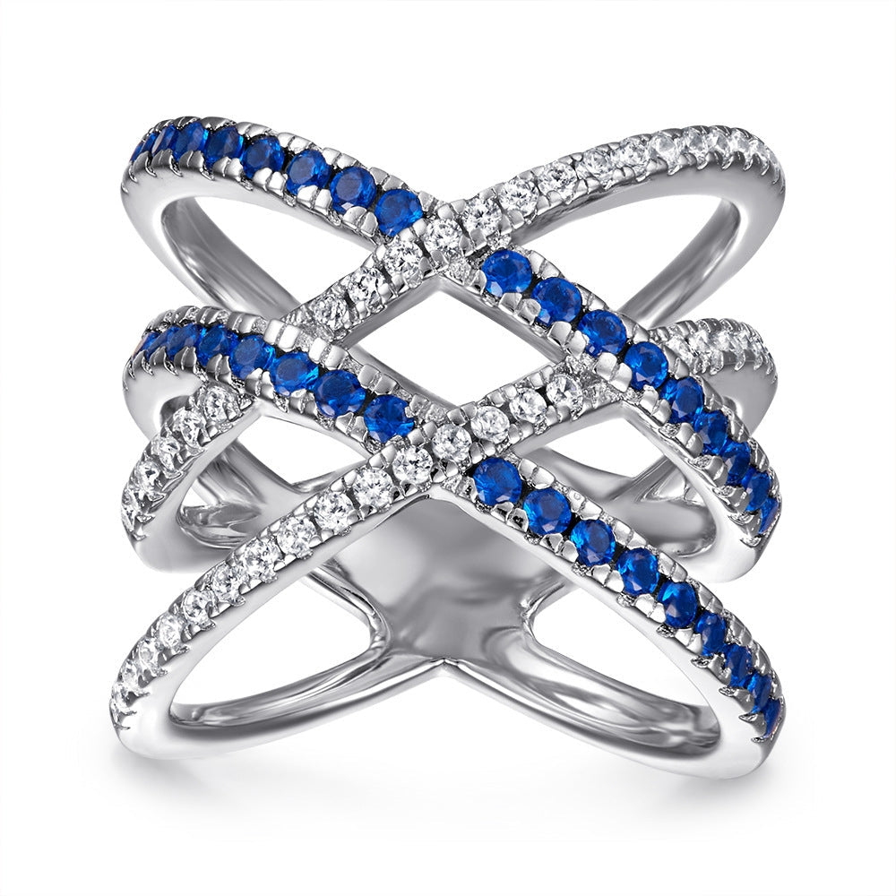 A beautiful line cross stunning ring made of 925 sterling silver, featuring white sapphire and blue zirconia stones, showcasing a modern design.