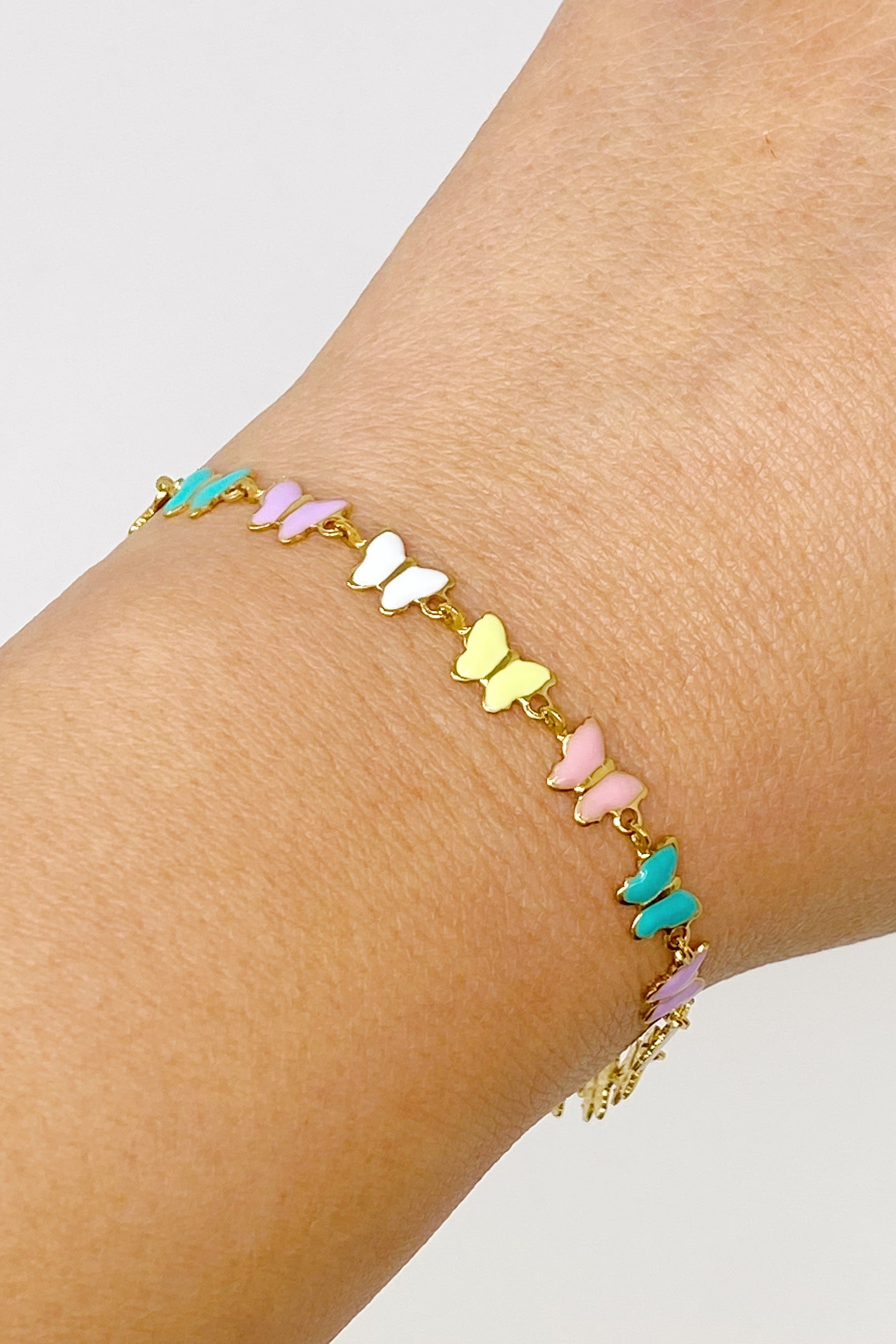 Linked Butterflies Bracelet featuring pastel butterflies and a reversible gold side, elegantly designed with intricate details.