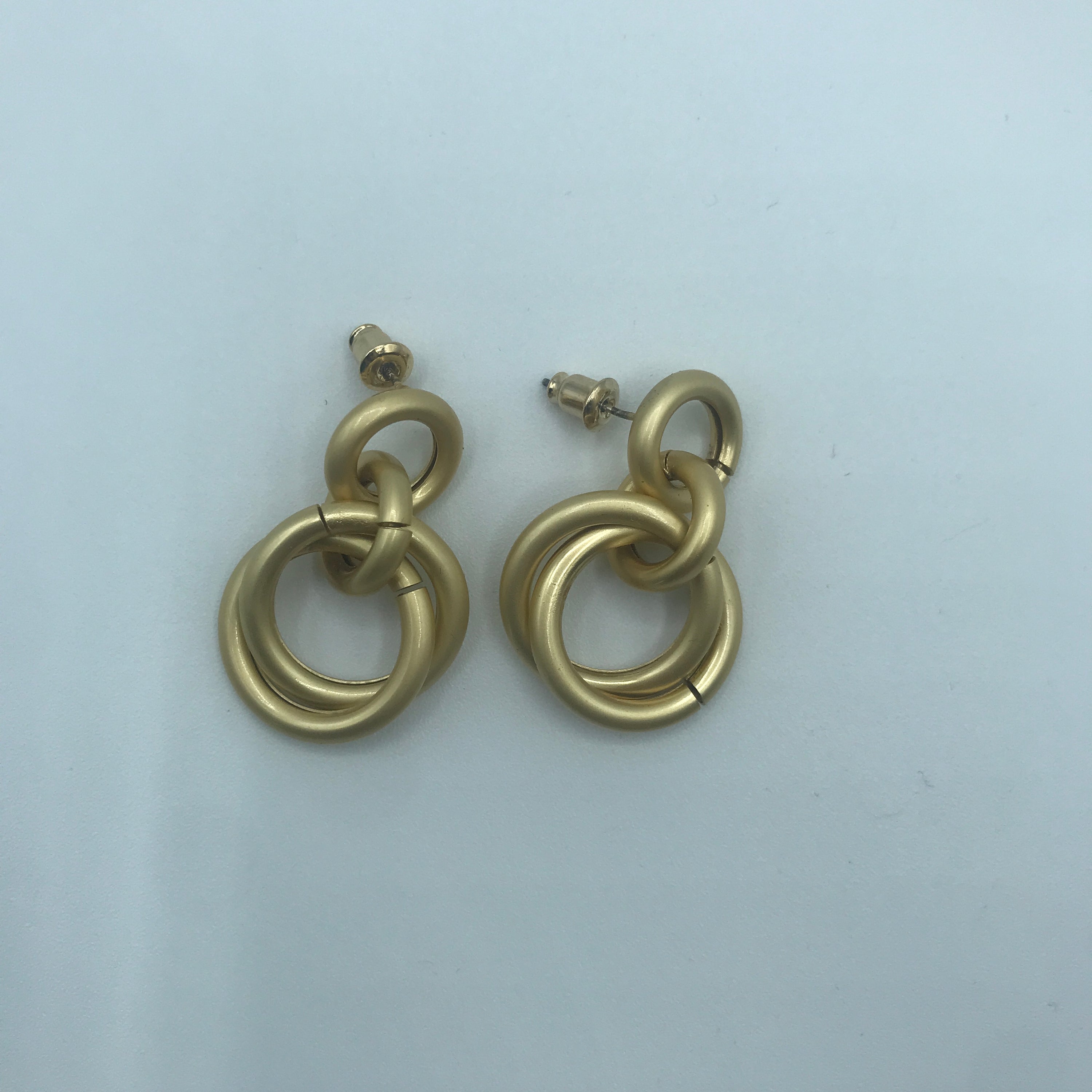 A pair of elegant linking crossed hoops earrings made from brass and s925 silver, showcasing a modern design.