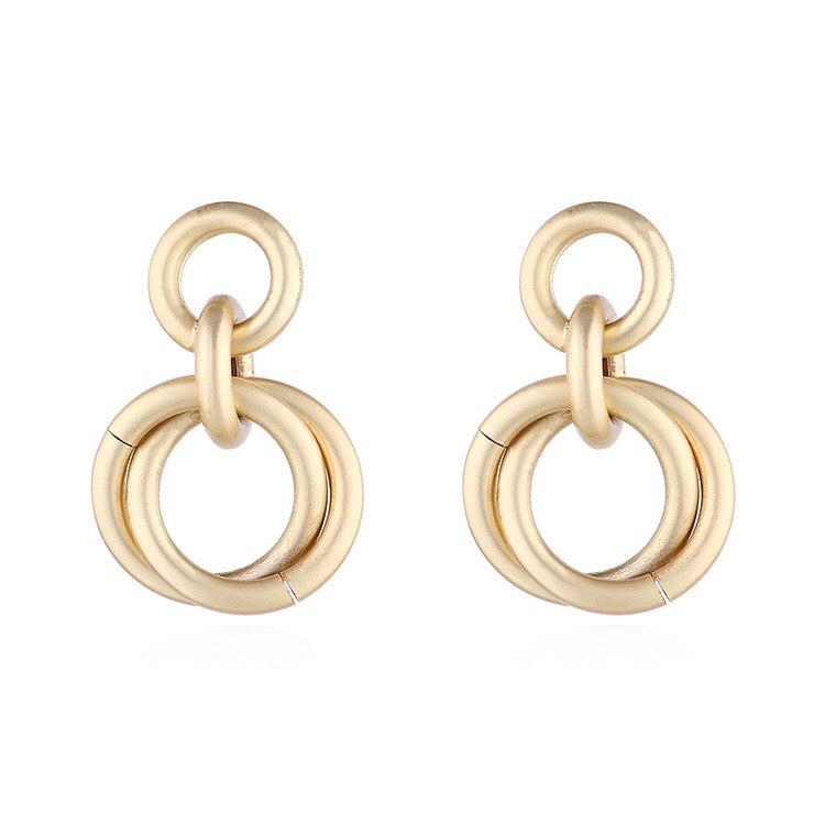 A pair of elegant linking crossed hoops earrings made from brass and s925 silver, showcasing a modern design.