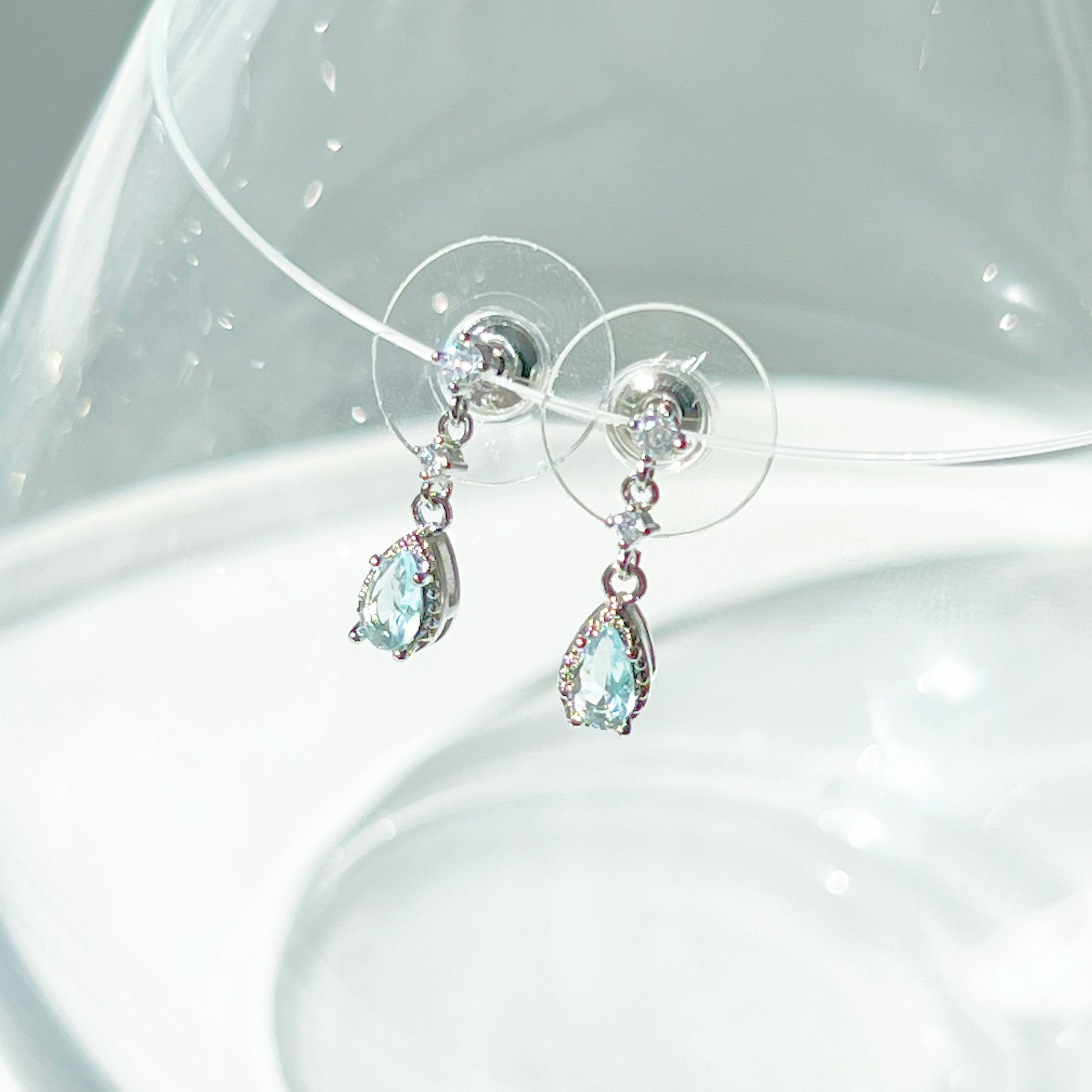 A pair of elegant little blue teardrop crystal earrings made from zircon, featuring a silver-plated bronze body and sterling silver studs.