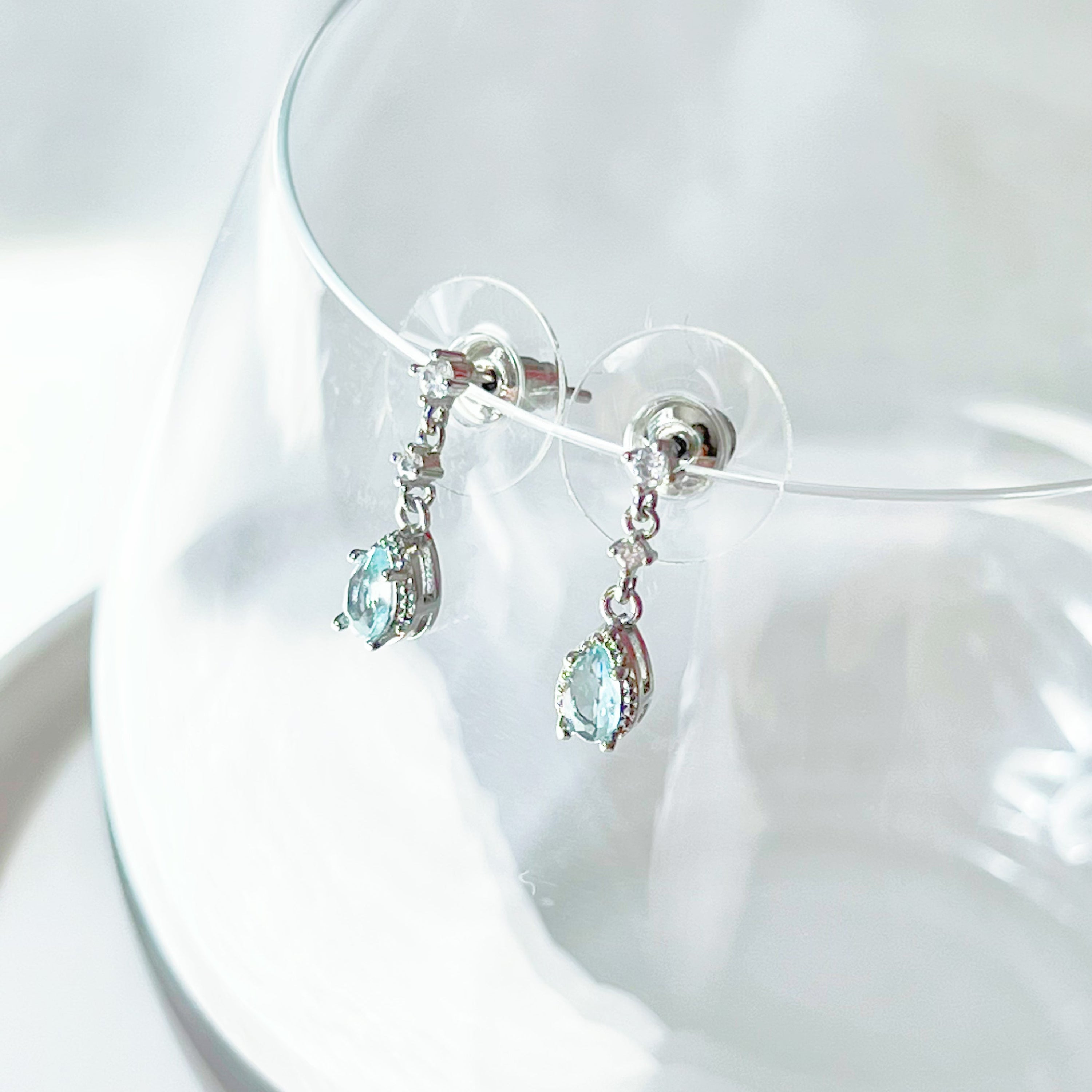 A pair of elegant little blue teardrop crystal earrings made from zircon, featuring a silver-plated bronze body and sterling silver studs.