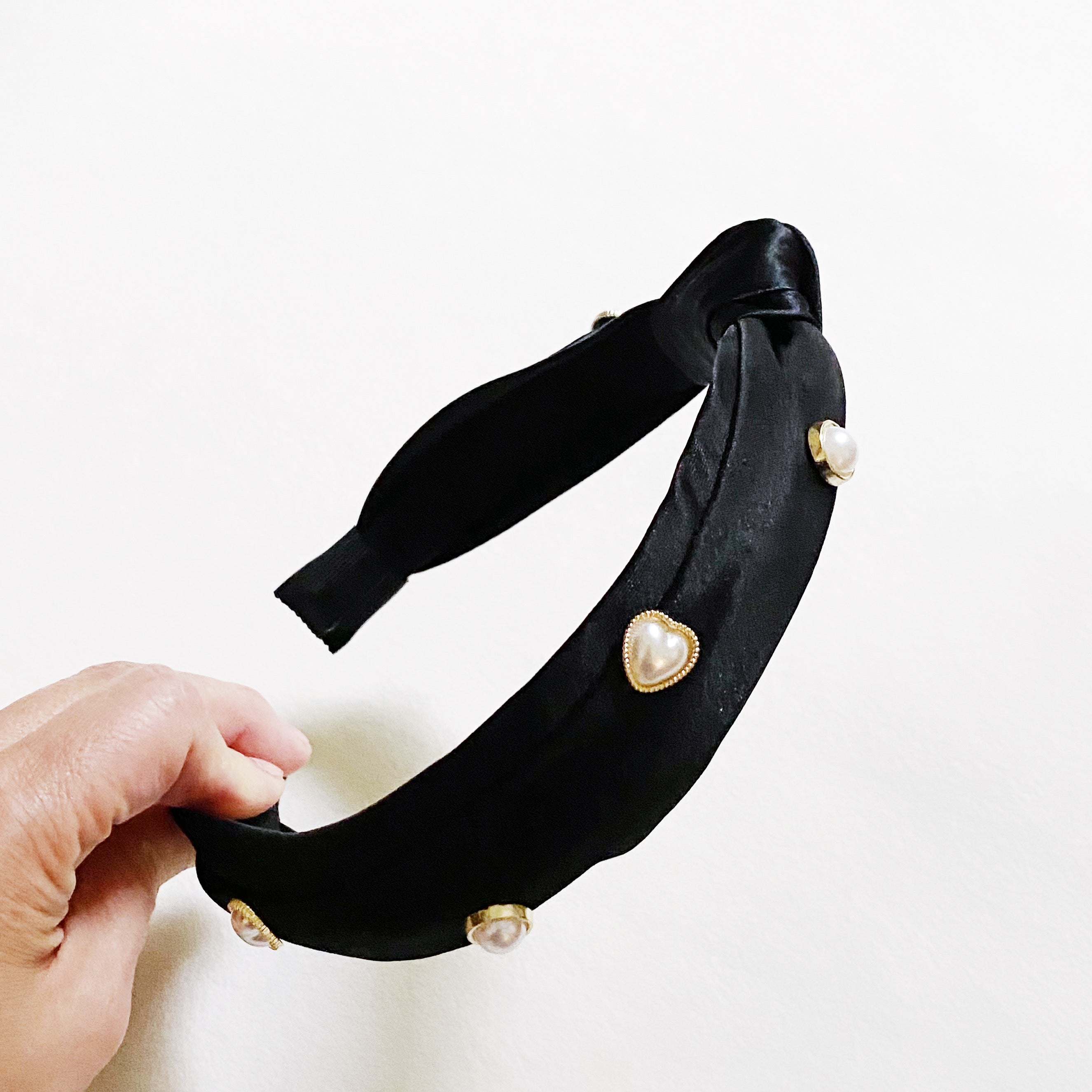 Liz Heart Embellished Headband featuring a chic knotted design and pearl embellishments, made from soft silky material.