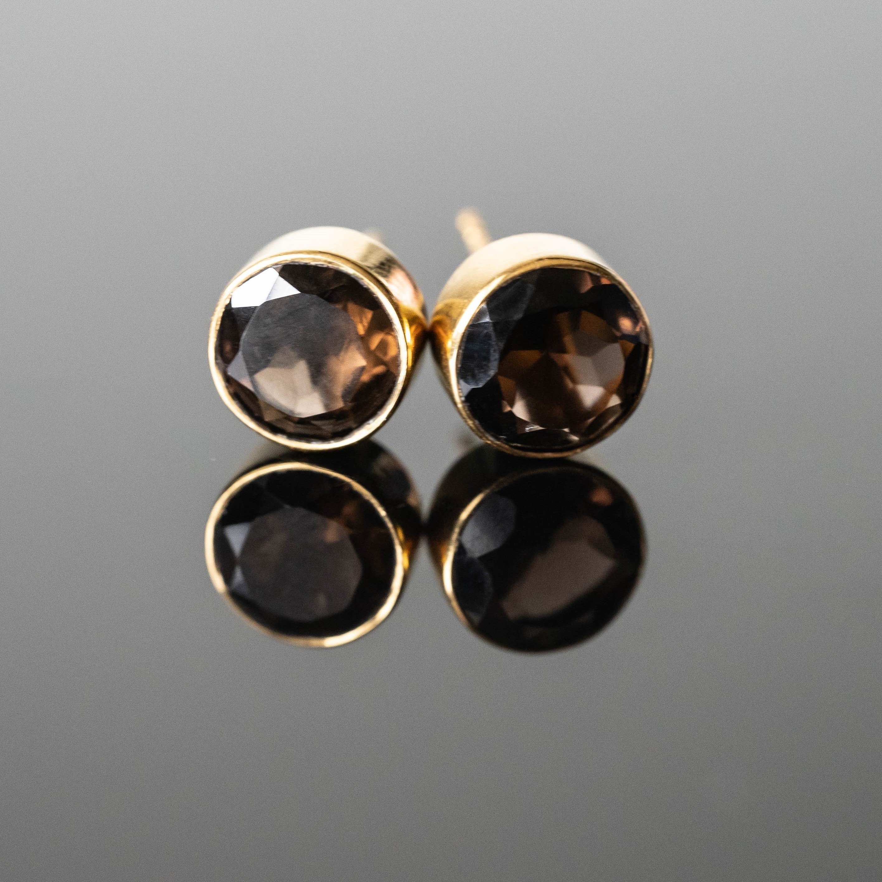 A pair of elegant Lizeth Smokey Quartz Round Studs featuring 8 mm smokey quartz stones set in gold plated 925 sterling silver.