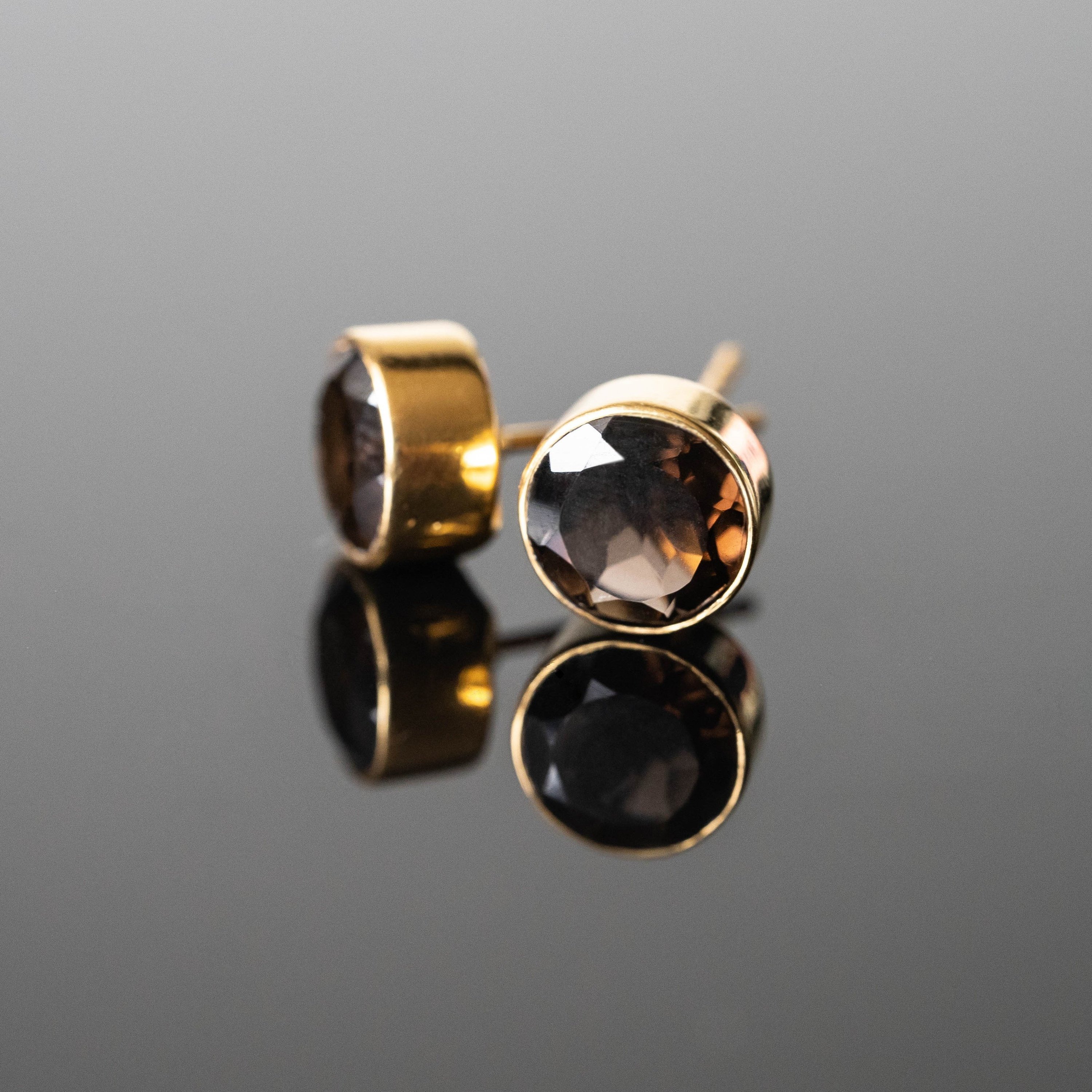 A pair of elegant Lizeth Smokey Quartz Round Studs featuring 8 mm smokey quartz stones set in gold plated 925 sterling silver.