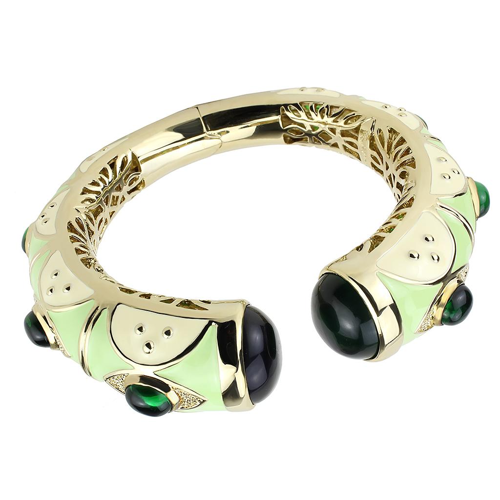 Gold brass bangle featuring a vibrant synthetic emerald centerpiece, elegantly designed for stylish wear.