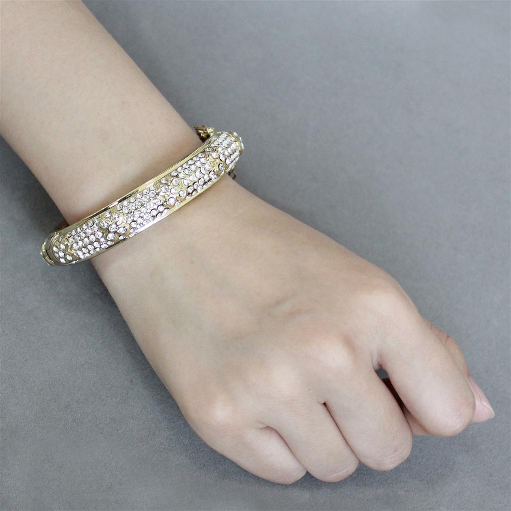 LO4339 Gold Brass Bangle featuring a clear top grade crystal centerpiece, elegantly designed for versatile wear.