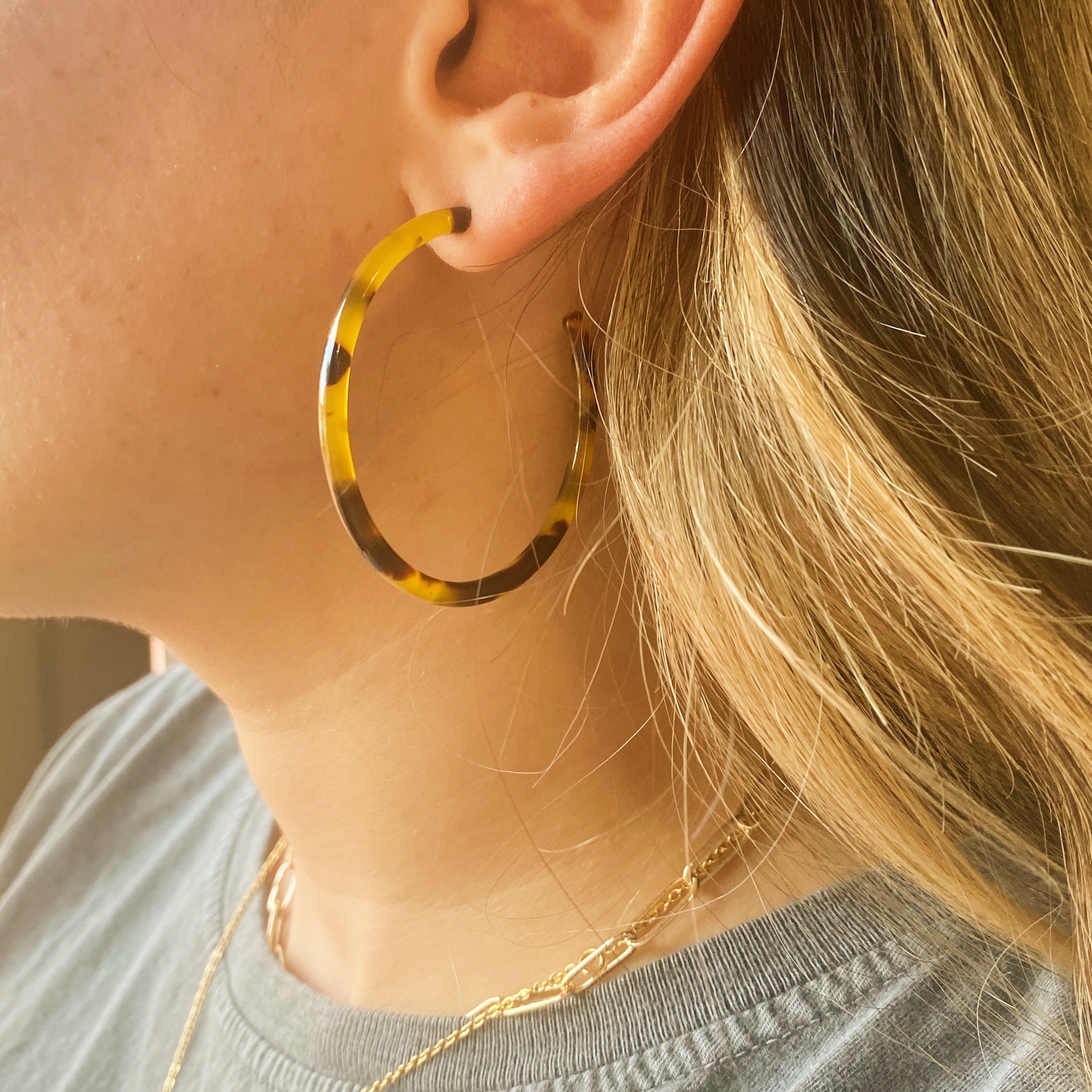 A pair of stylish skinny tortoise hoop earrings with a 2-inch diameter, showcasing a classic tortoise shell pattern.