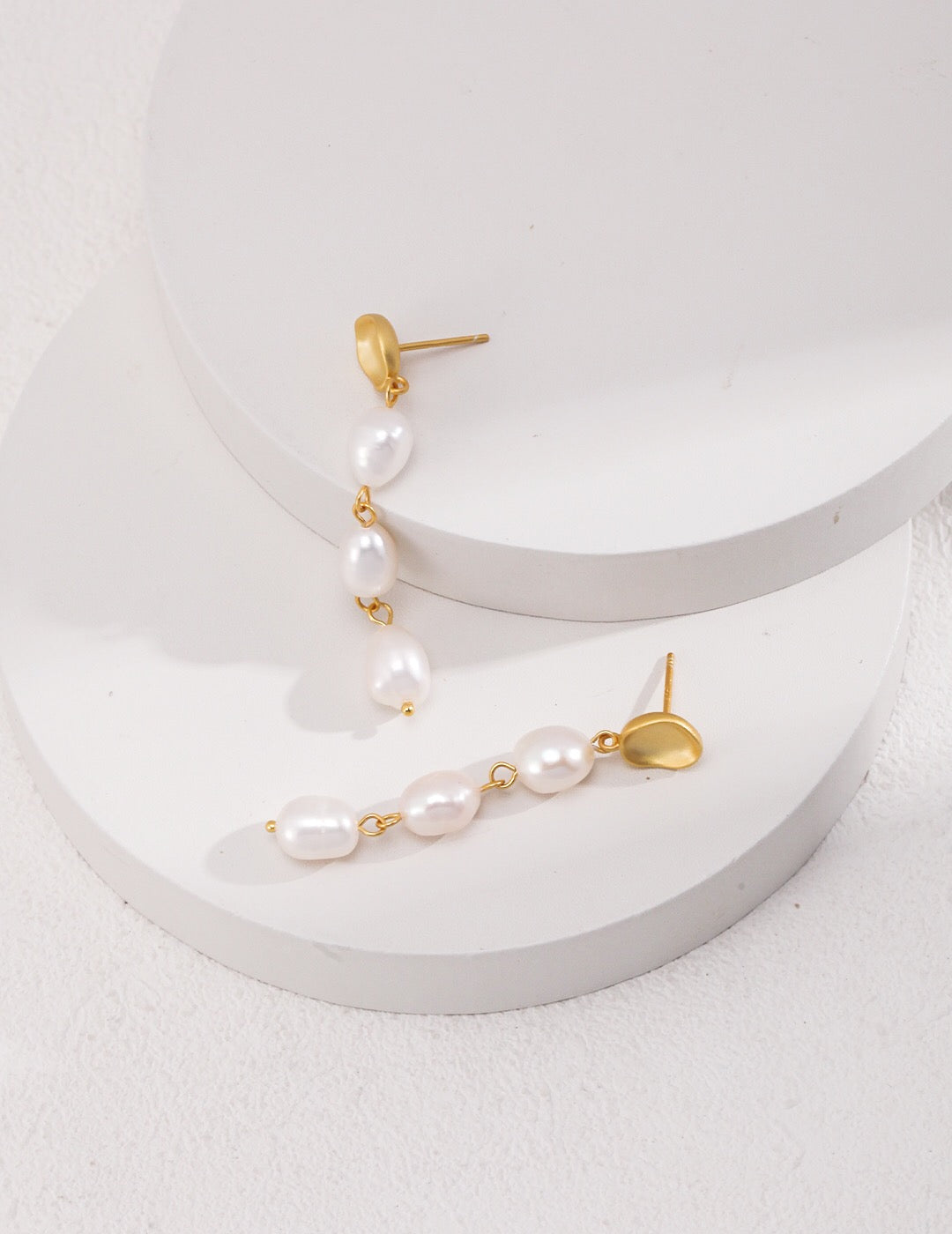 Elegant Long Baroque Pearls Dangle Earrings featuring natural pearls and gold vermeil, showcasing their unique shapes and luxurious design.