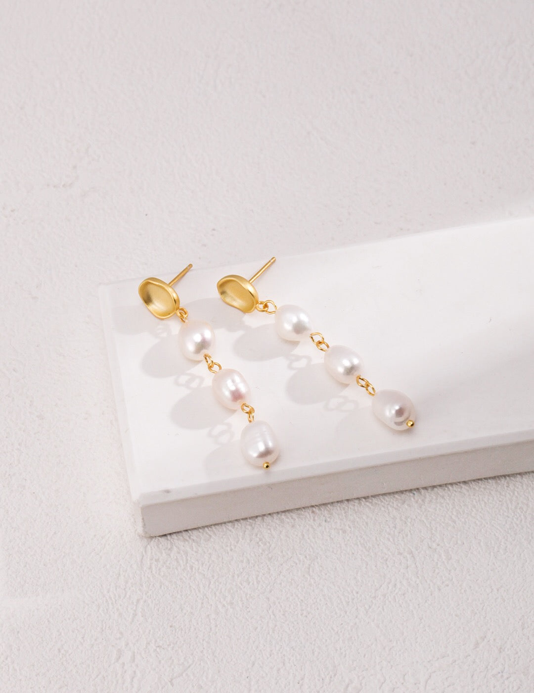 Elegant Long Baroque Pearls Dangle Earrings featuring natural pearls and gold vermeil, showcasing their unique shapes and luxurious design.