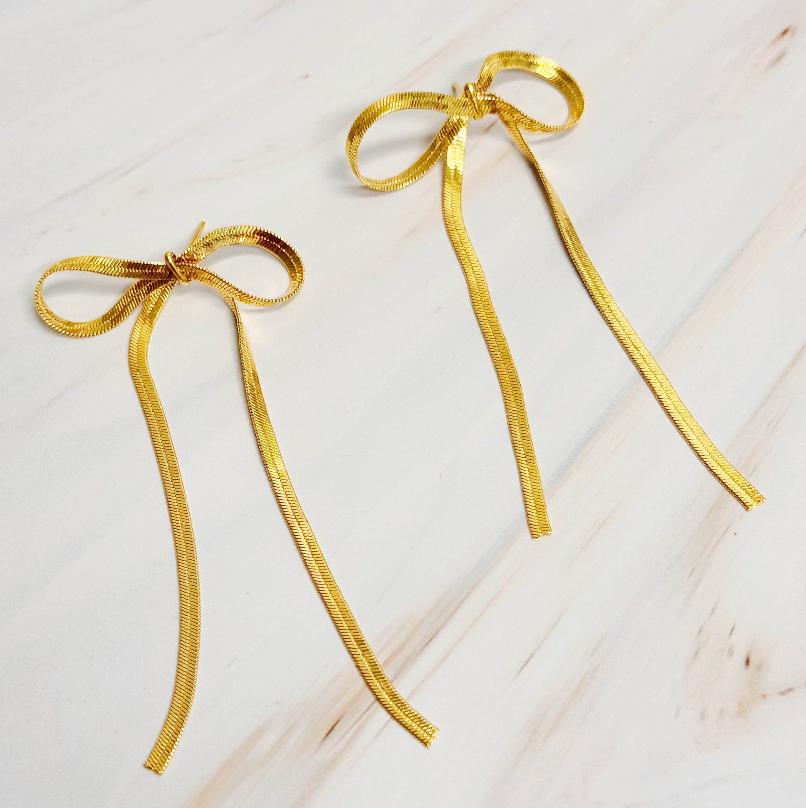 Elegant Long Drop Bow Earrings in 18k gold plated brass, showcasing a unique elongated design.