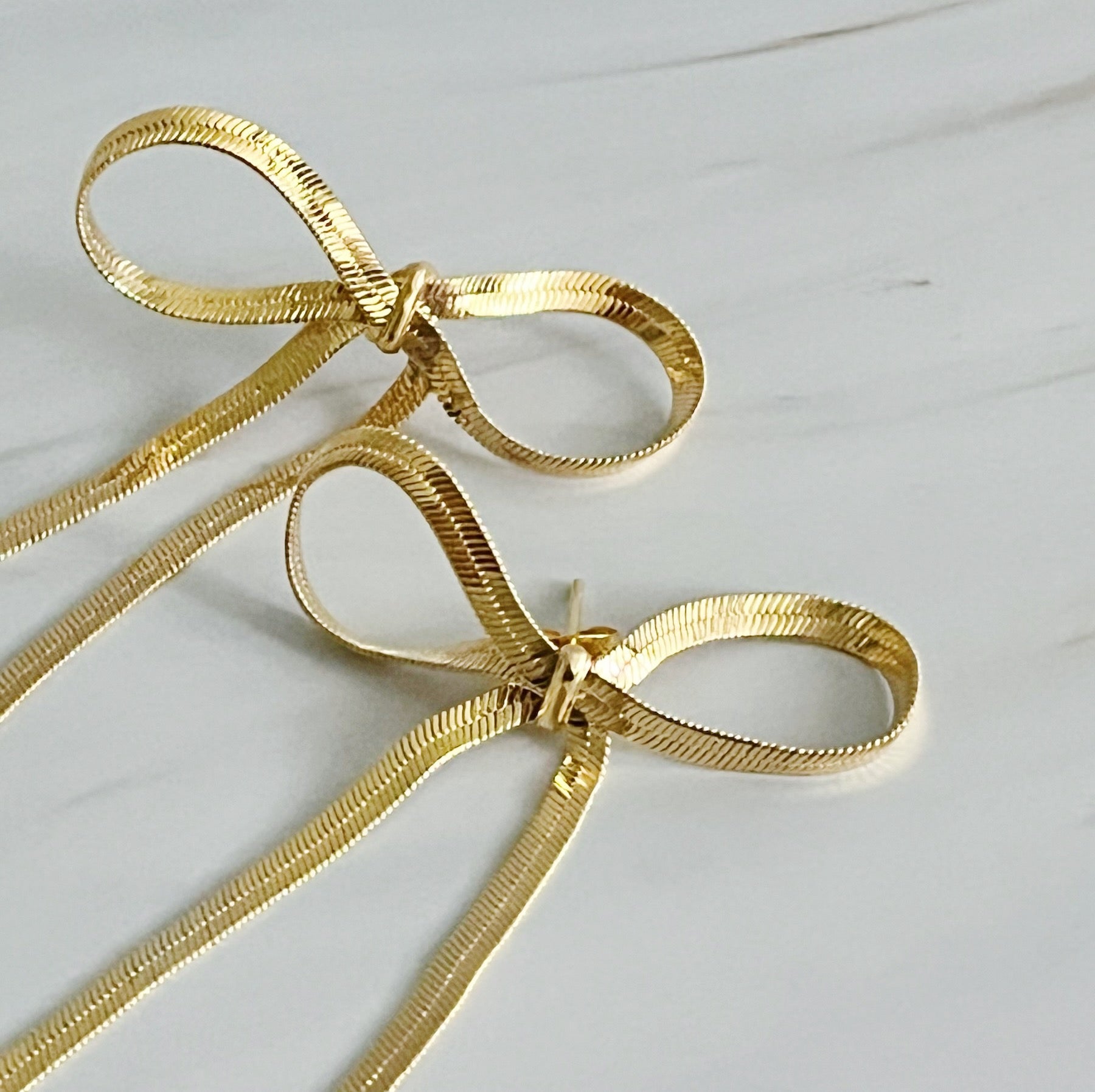 Elegant Long Drop Bow Earrings in 18k gold plated brass, showcasing a unique elongated design.