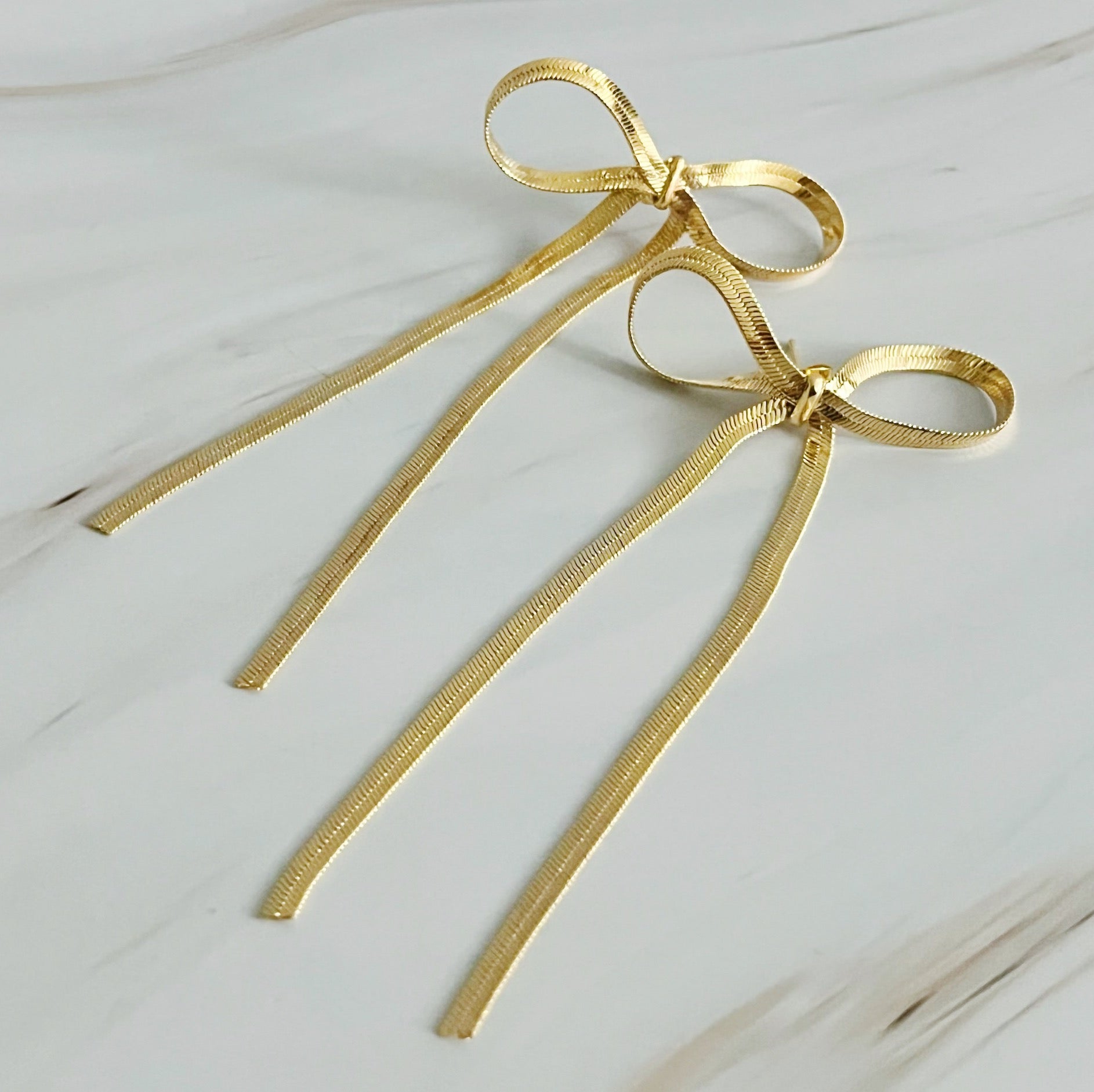 Elegant Long Drop Bow Earrings in 18k gold plated brass, showcasing a unique elongated design.