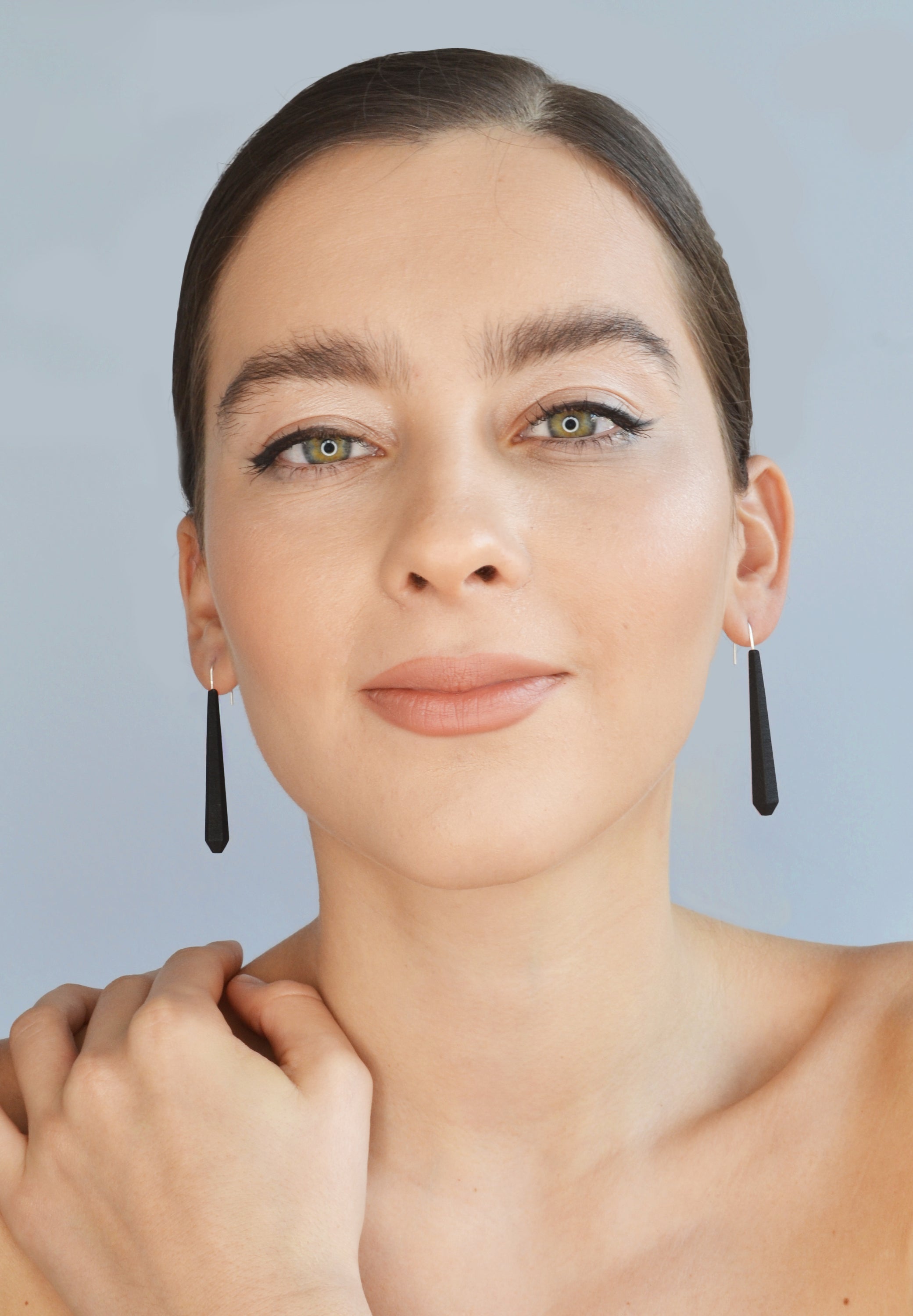 Long Pentagon Earrings in vibrant colors, featuring a geometric design with sterling silver hooks, displayed in a fabric pouch.