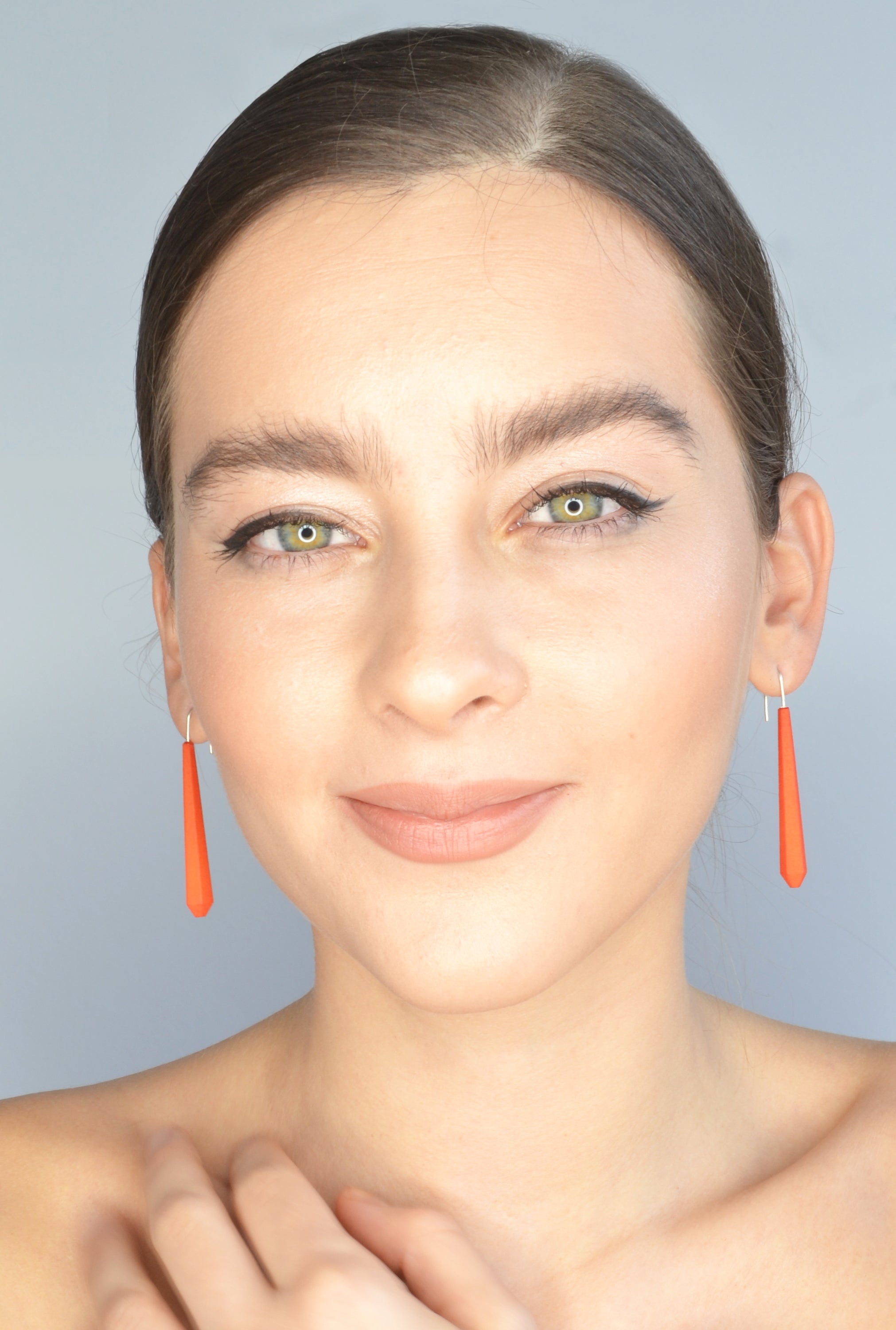 Long Pentagon Earrings in vibrant colors, featuring a geometric design with sterling silver hooks, displayed in a fabric pouch.