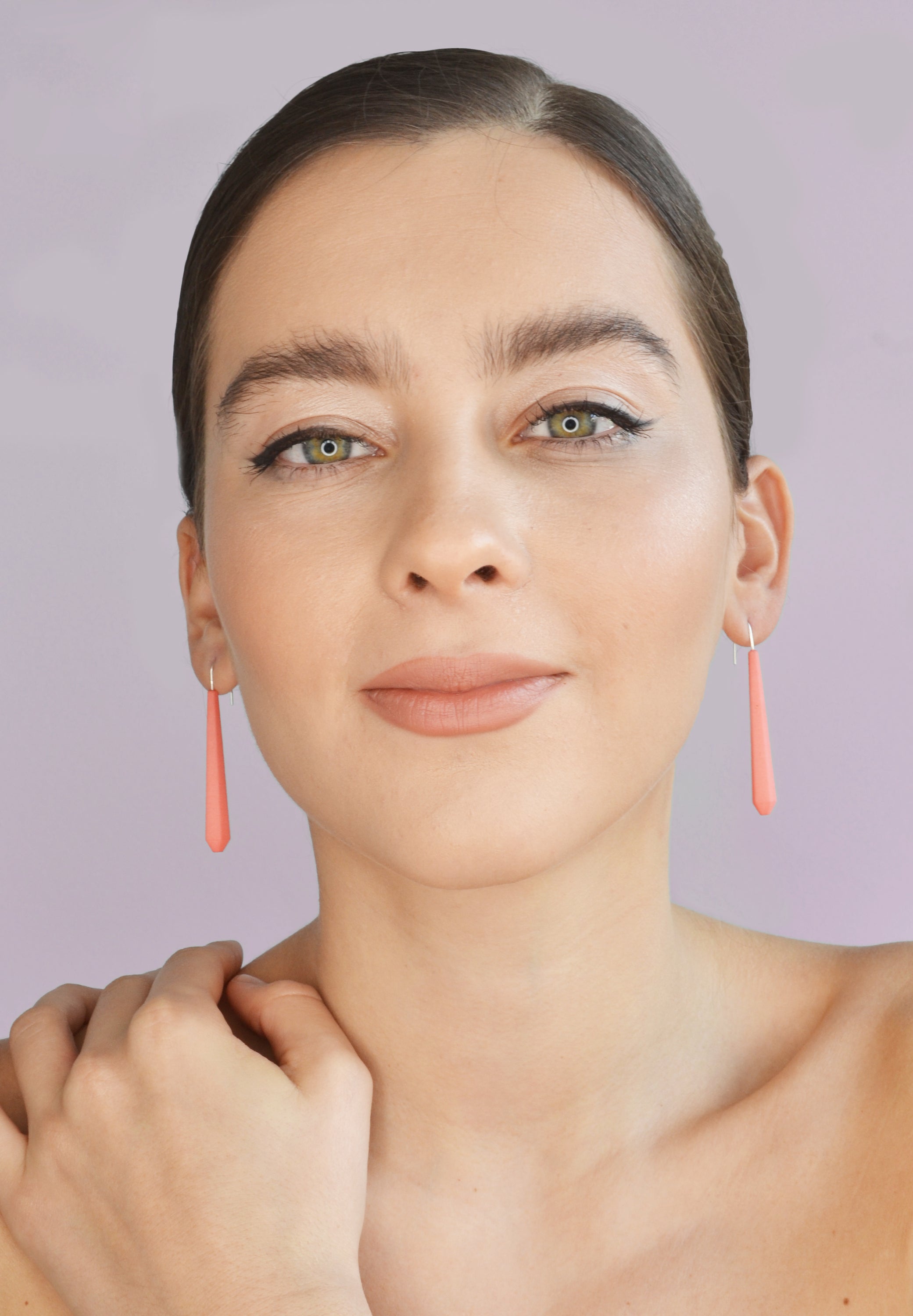 Long Pentagon Earrings in vibrant colors, featuring a geometric design with sterling silver hooks, displayed in a fabric pouch.