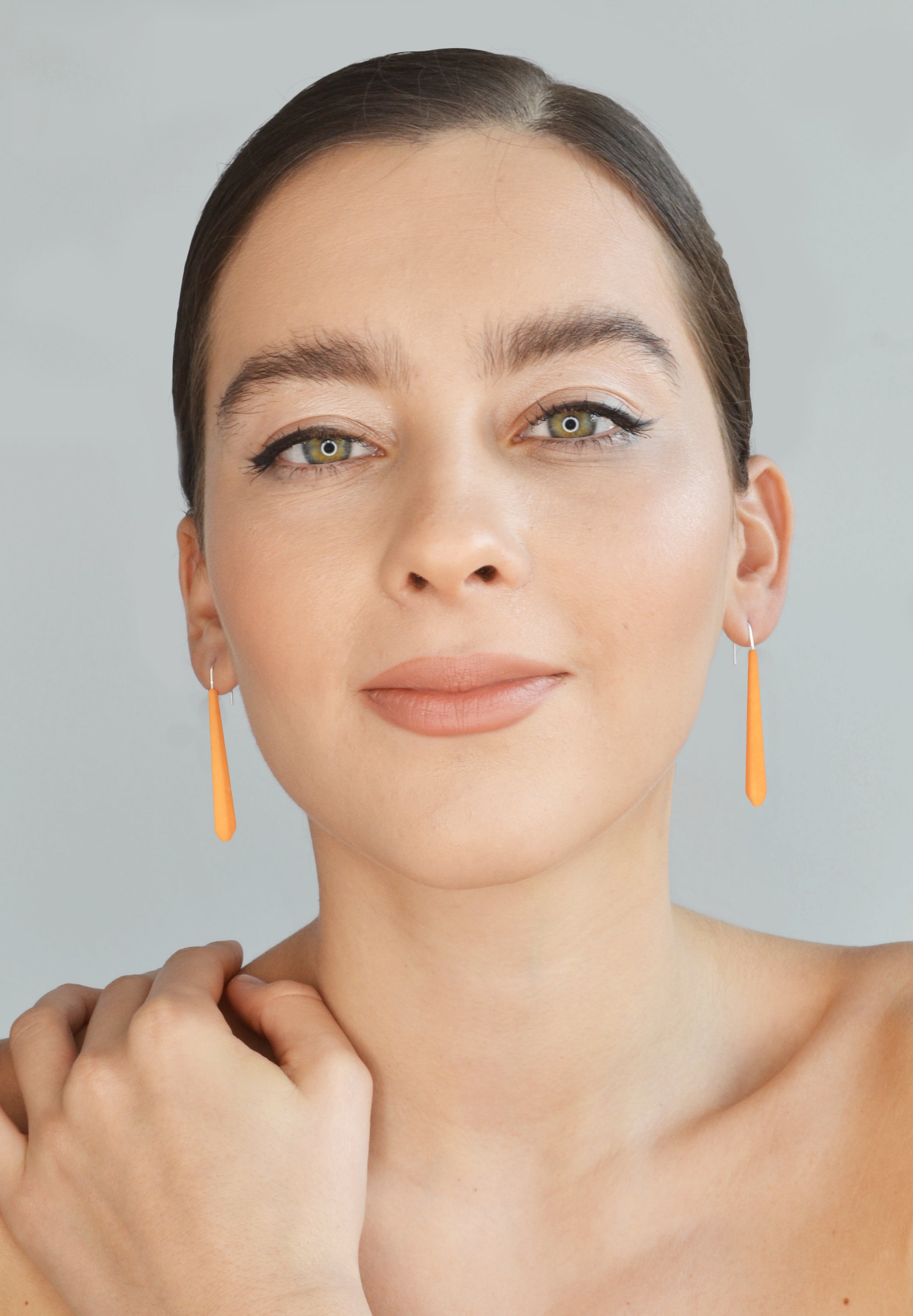 Long Pentagon Earrings in vibrant colors, featuring a geometric design with sterling silver hooks, displayed in a fabric pouch.