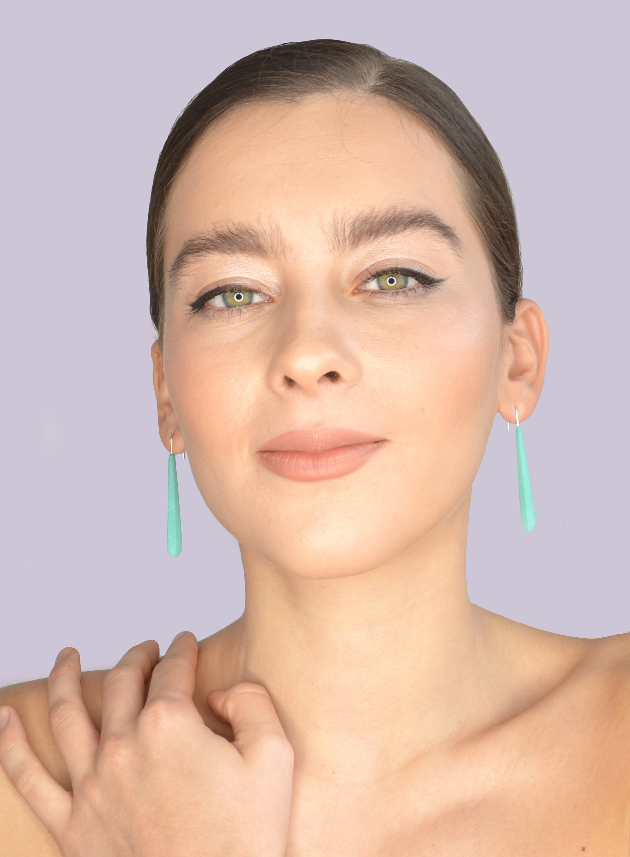 Long Pentagon Earrings in vibrant colors, featuring a geometric design with sterling silver hooks, displayed in a fabric pouch.