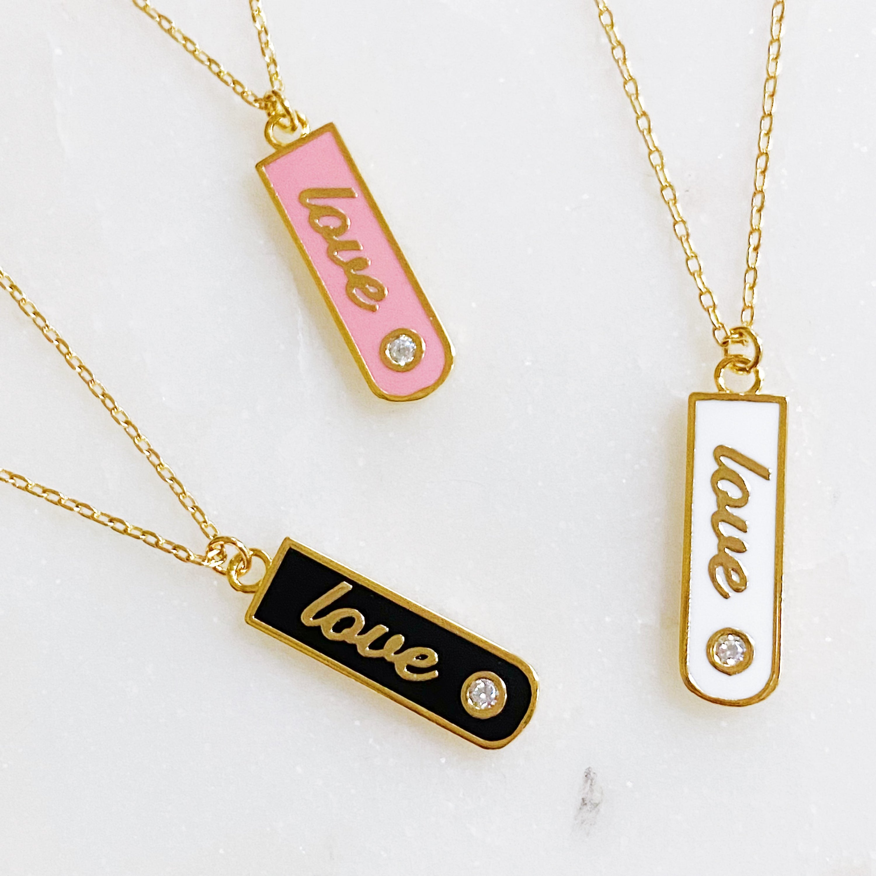 Gold-plated Love Drop Bar Necklace featuring a rounded pendant with LOVE engraving and a tiny shiny stone.