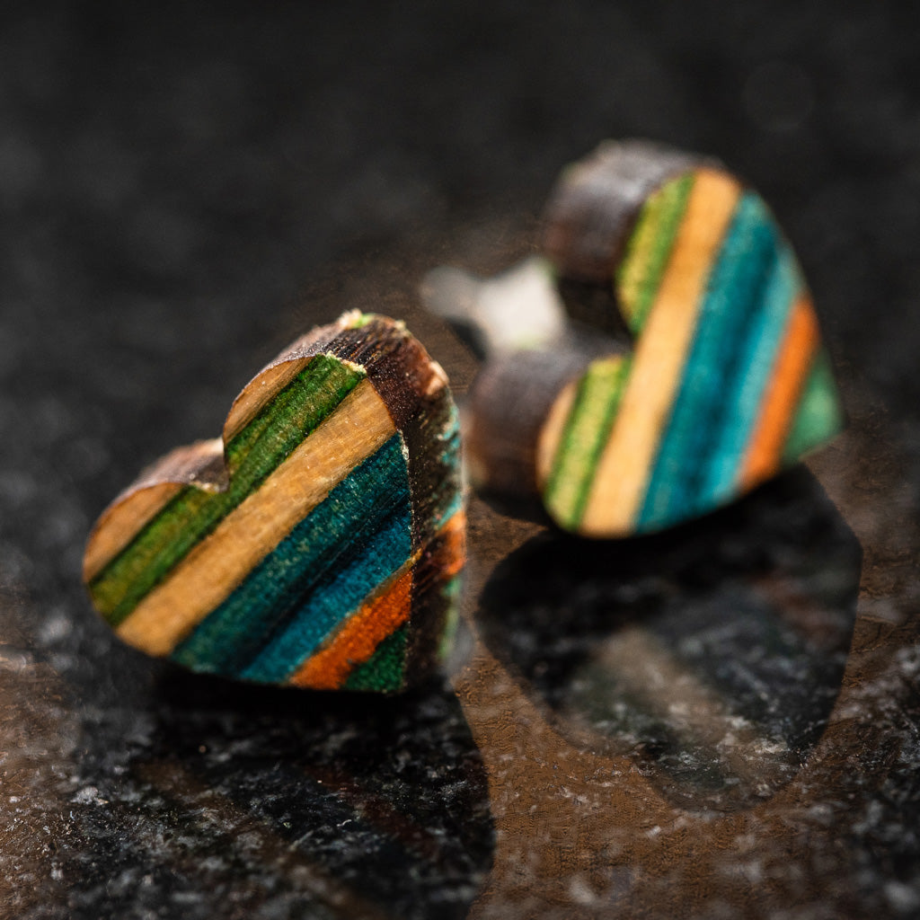 Handcrafted Love Heart Recycled Skateboard Wooden Stud Earrings showcasing vibrant colors and unique patterns.