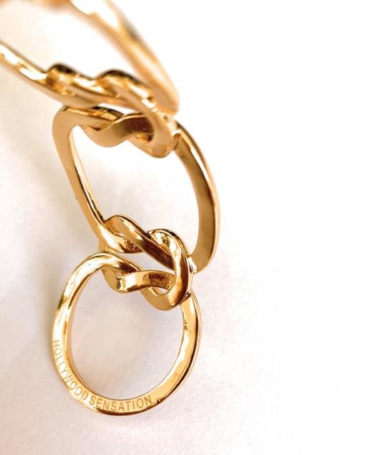 Elegant Love Knot Bracelet in 18k gold plating, symbolizing eternal love, displayed on a soft fabric background.